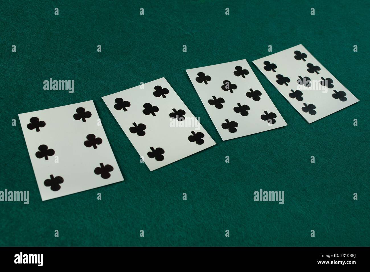 Old west era playing card on green gambling table. 6, 7, 8, 9 of clubs. Stock Photo