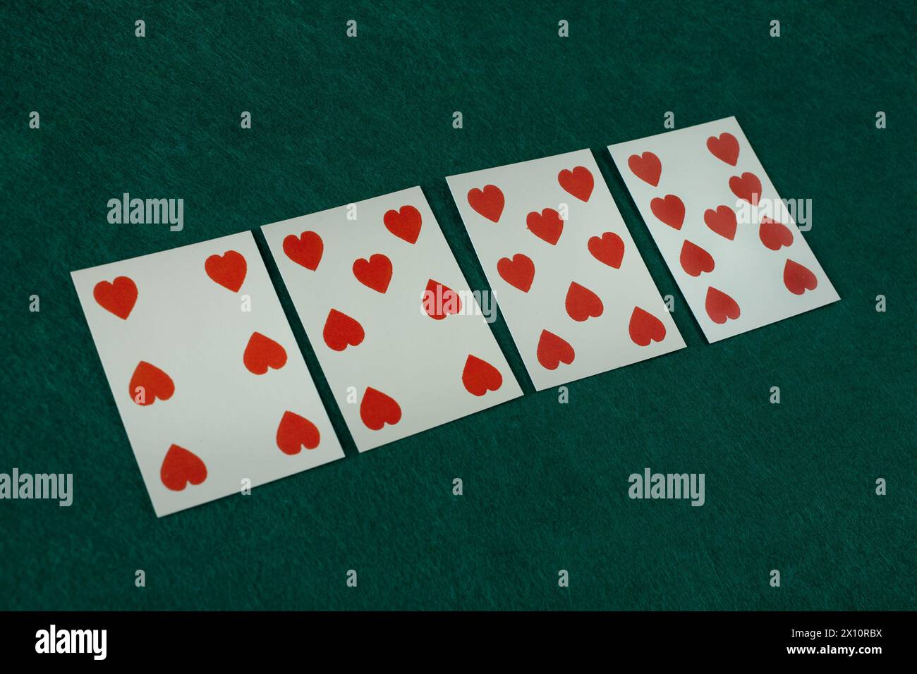 Old west era playing card on on green gambling table. 6, 7, 8, 9 of hearts. Stock Photo