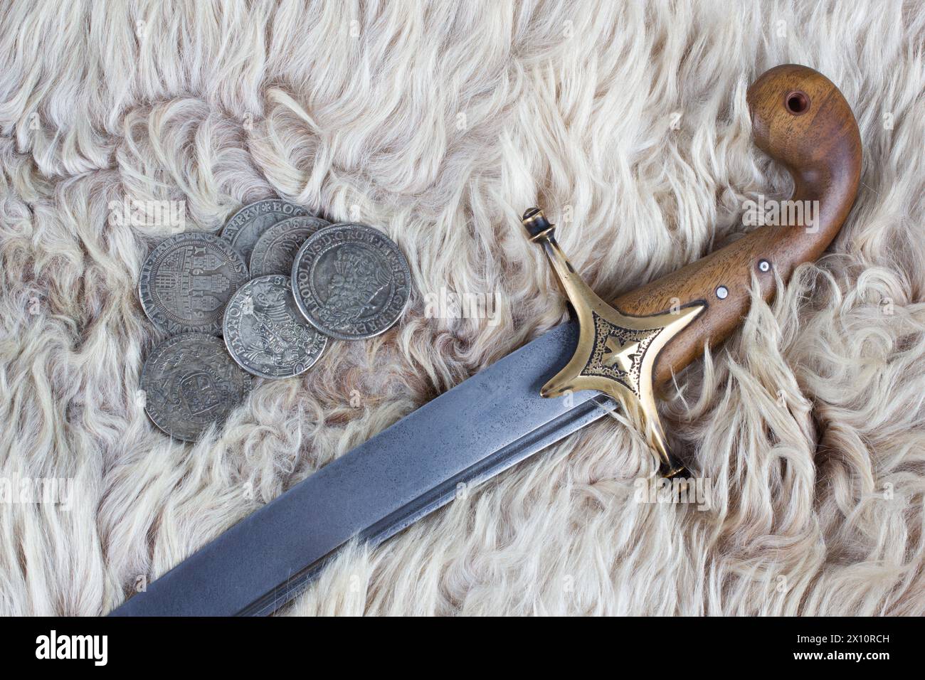 Ukraine Saber Sword with silver taller coins on fur background, 17th century. Poland, Lithuania, Hungary, Ukraine. Stock Photo