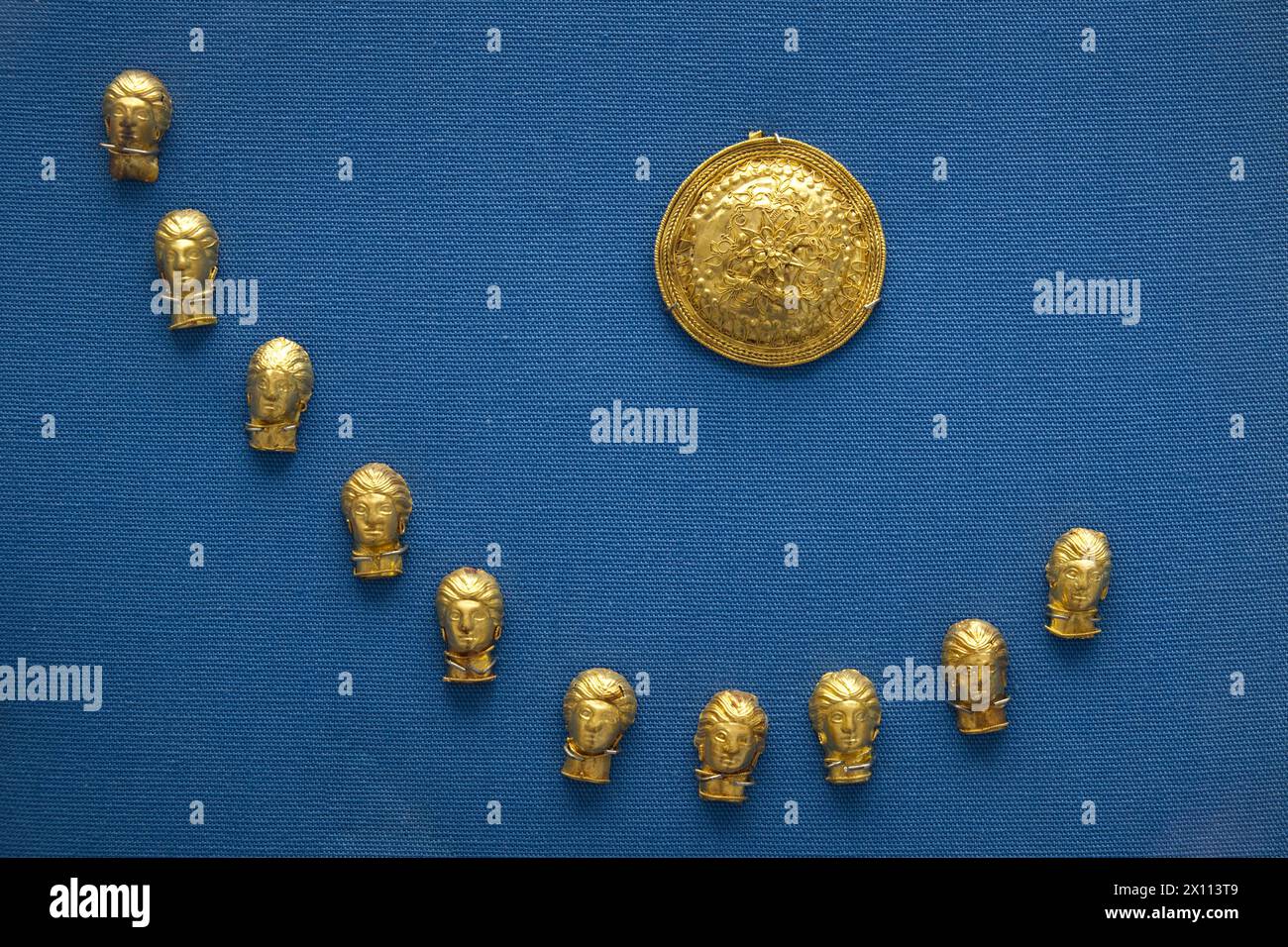 Circular gold brooch with filagree decoration Ten gold pendants in the form of female heads Made in southern Italy about 340-300BC Stock Photo