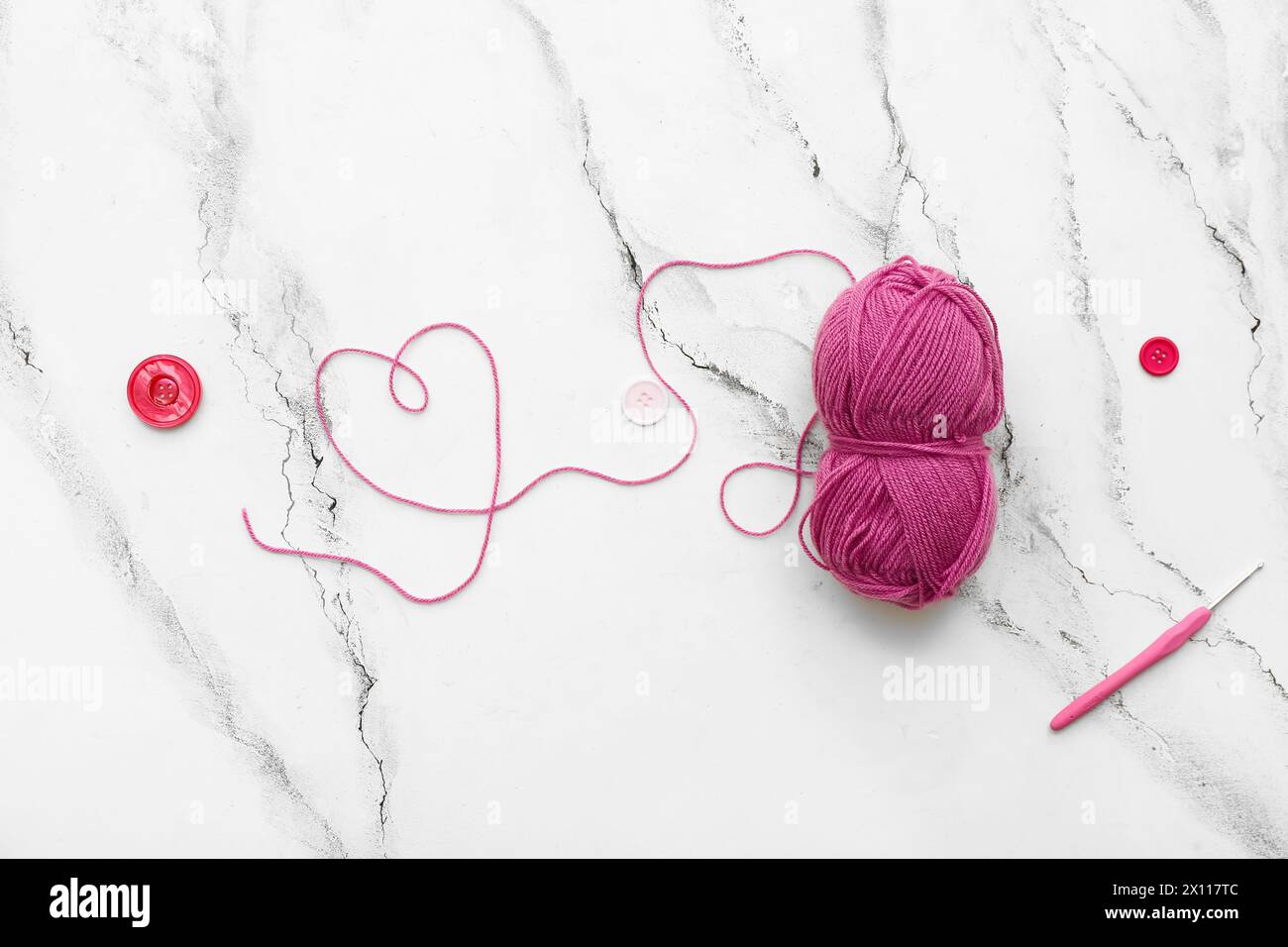 Yarn ball, crochet hook and buttons on white grunge background Stock Photo