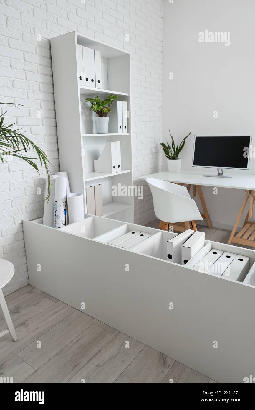 Interior of office with tables, shelf units and plants Stock Photo - Alamy