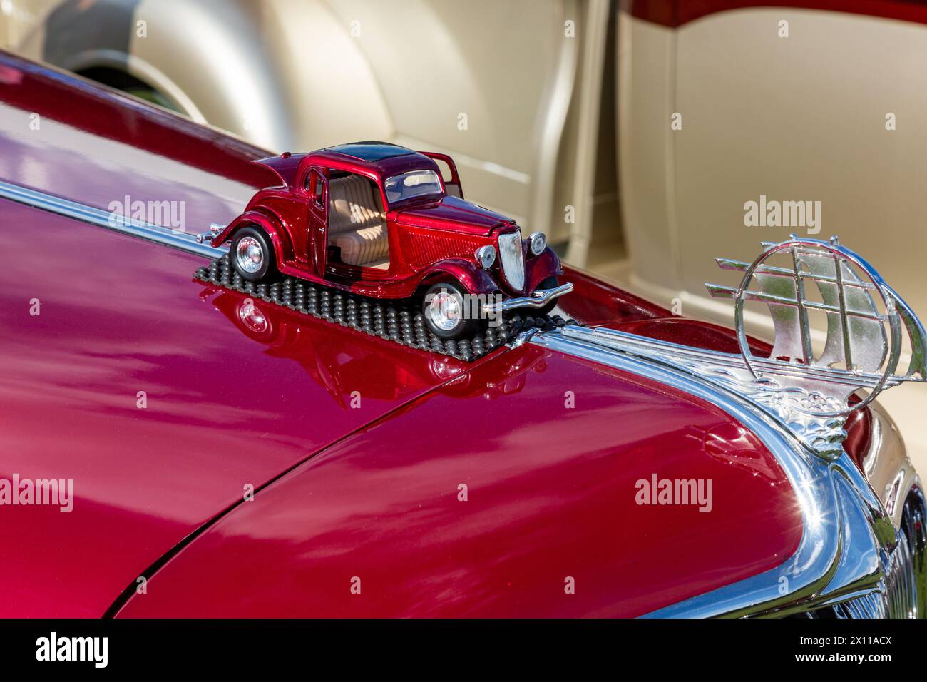 A miniature replica of this classic red Plymouth sits the hood. Stock Photo
