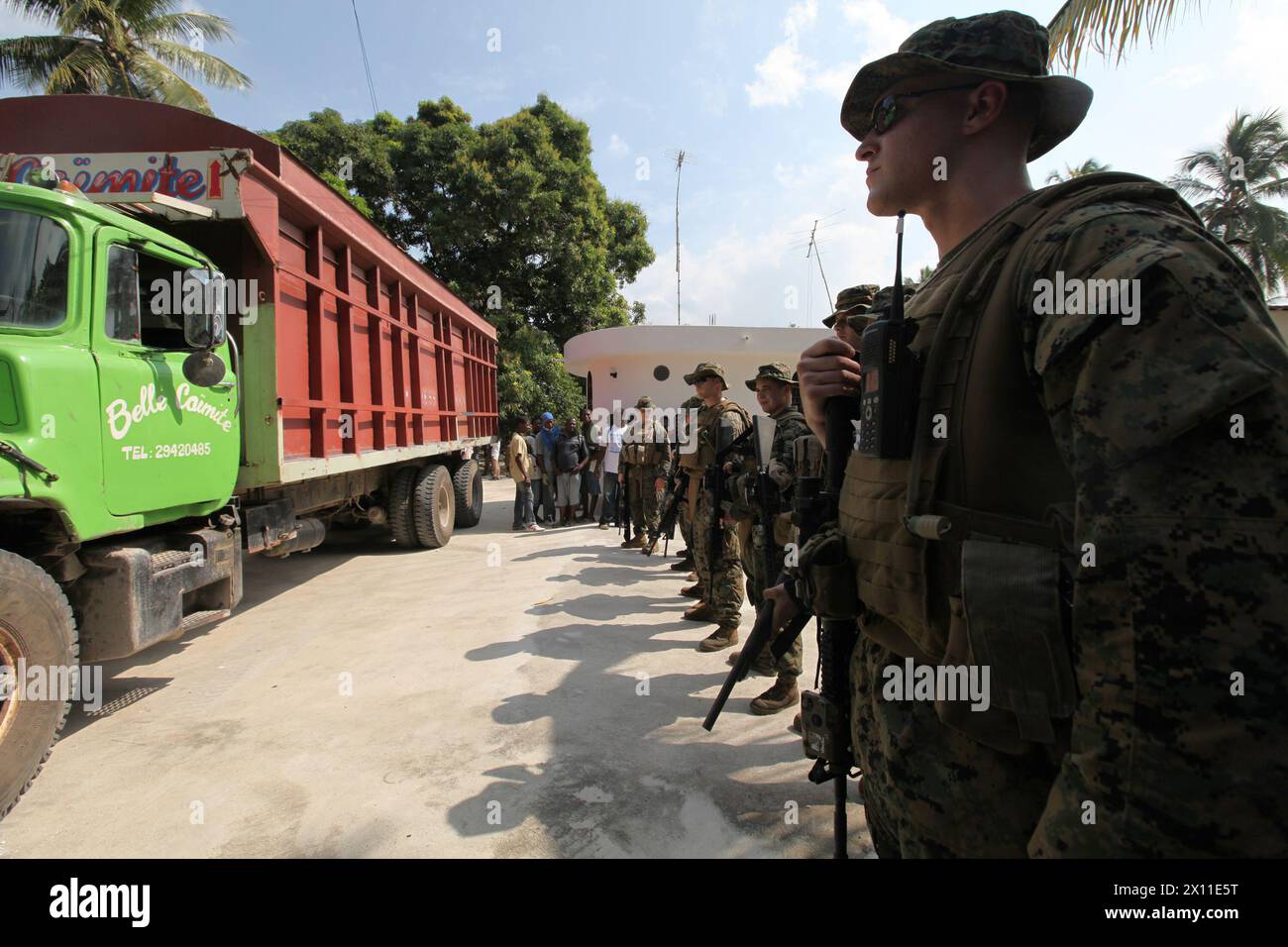 U.S. Marine 1st Lt. Gregory Meyer, a platoon commander with Battalion Landing Team, 3rd Battalion, 2nd Marine Regiment, 22nd Marine Expeditionary Unit, along with other Marines from the BLT provide security for a food supply truck during a supply mission in Leogane, Haiti, Jan. 20, 2010. The supply mission was the first humanitarian assistance operation conducted by the 22nd MEU since they arrived in Haiti. Stock Photo