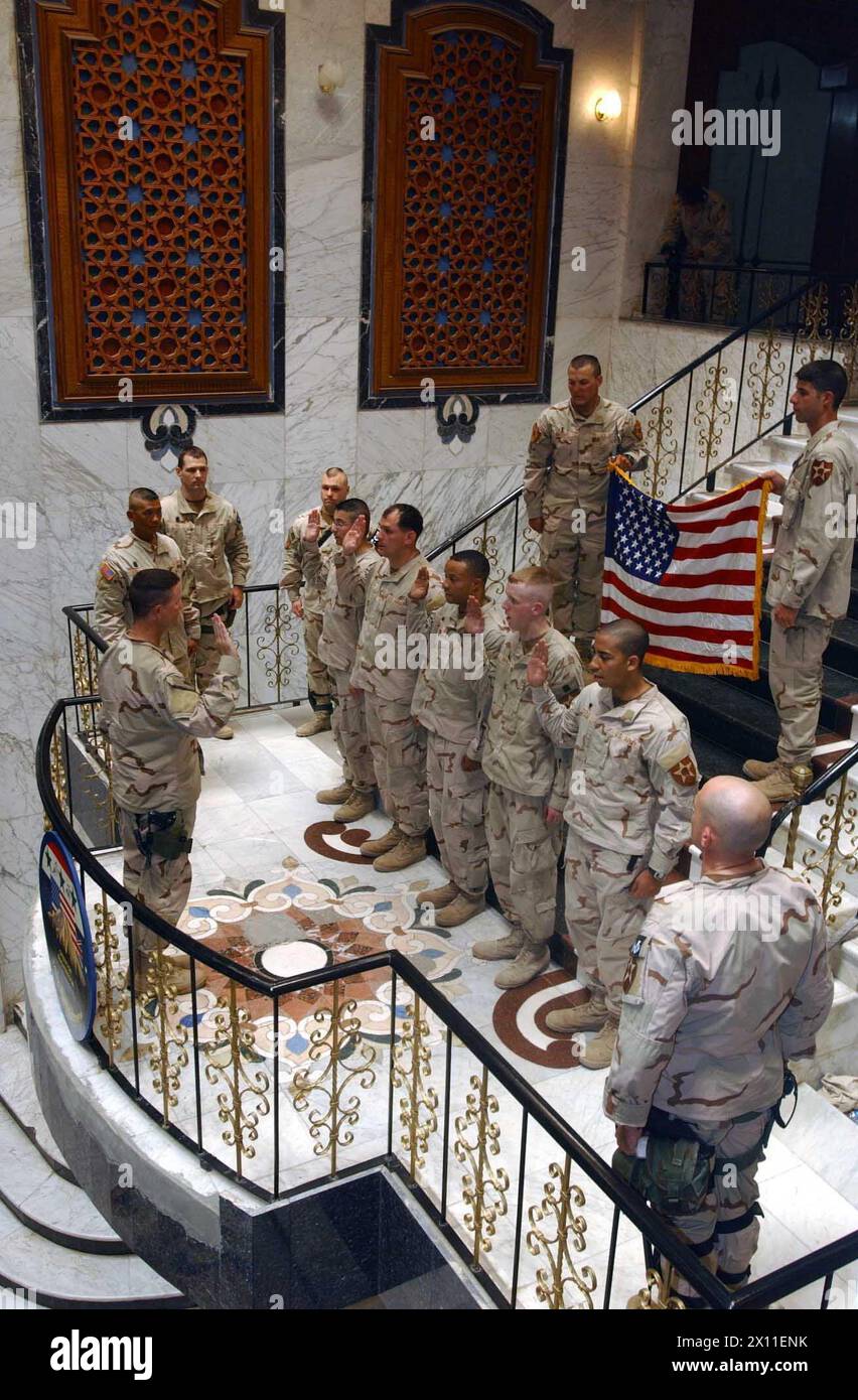 Soldiers from the fire support team (FIST) of 1st Battalion, 23rd Infantry Regiment reenlist on the steps of one of Saddams former palaces in Mosul. Col. Michael Rounds, commander of 3rd Brigade, 2nd Infantry Division (Stryker Brigade Combat Team) swears in the FIST Soldiers ca. June 20, 2004 Stock Photo