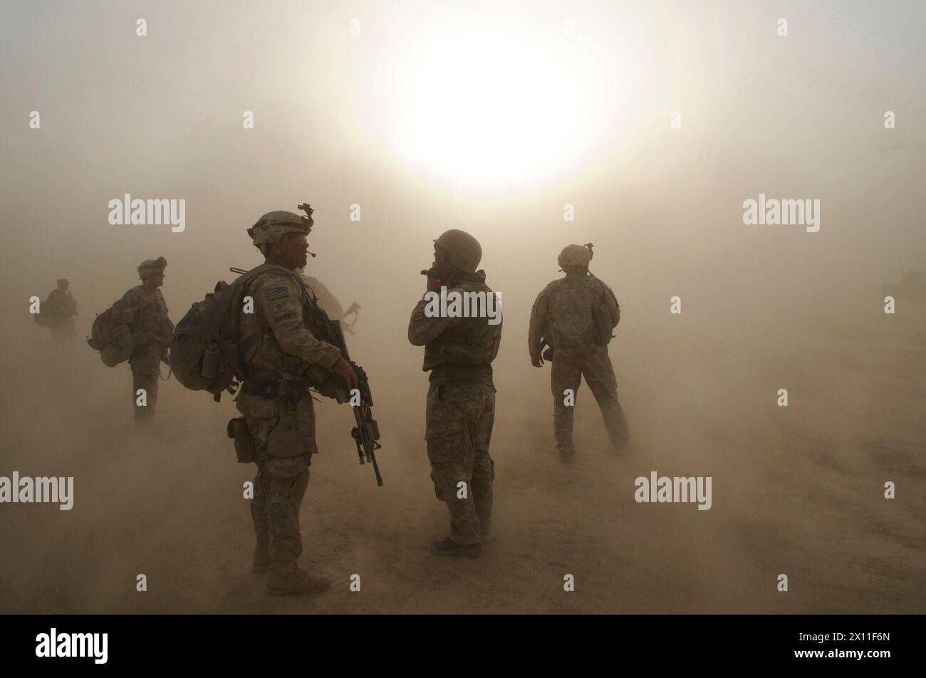 Members of 1st Platoon, Company C, 1st Battalion, 501st Infantry Regiment, 4th Brigade Combat Team (Airborne), 25th Infantry Division, watch as CH-47 Chinook Helicopters circle above during a dust storm at Forward Operating Base Kushamond, Afghanistan, during preparation for an air-assault mission ca. September 07, 2004 (metadata lists year as 2009) Stock Photo