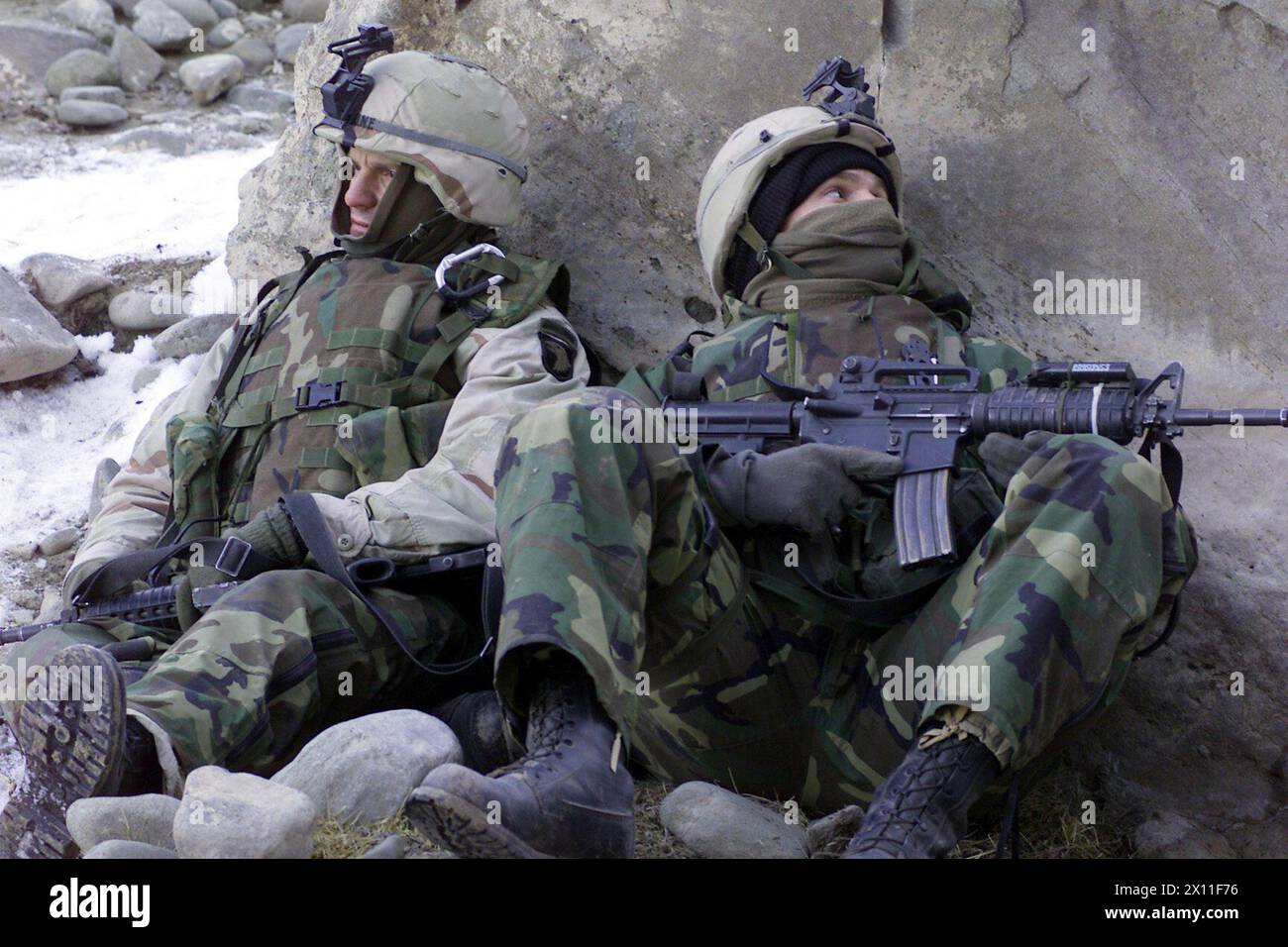 Original Caption: U.S. Army Soldiers with the 1st Battalion, 187th Infantry Regiment, 101st Airborne Division (Air Assault), scan the nearby ridgeline for enemy movement during Operation Anaconda (Afghanistan), March 4, 2002 ca. April 03, 2004 Stock Photo