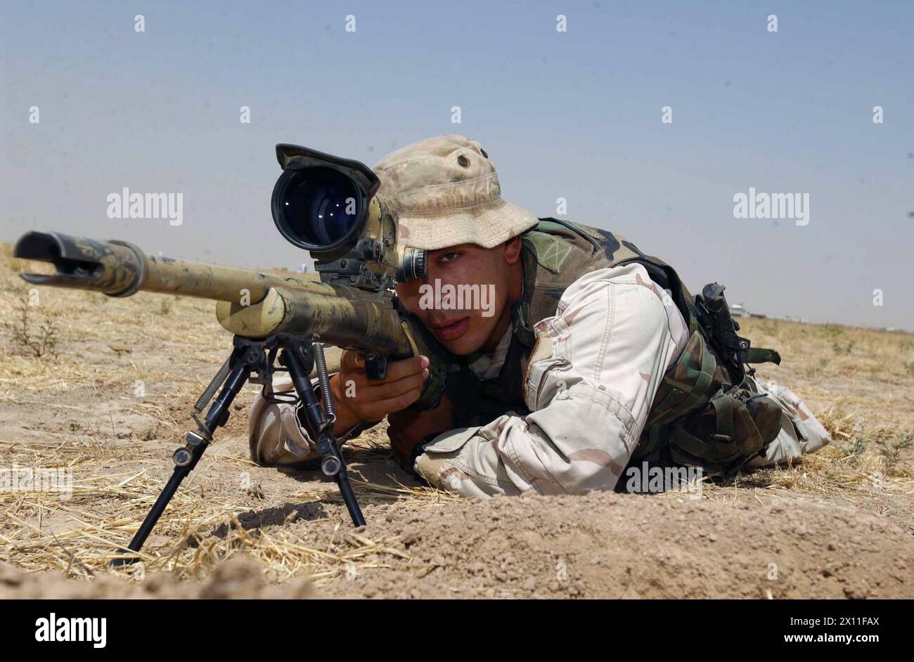 Spc. John Shore looks through the scope of his sniper rifle during an operation in Tall Afar, Iraq. He is a member of the 5th Battalion, 20th Infantry Regiment, 3rd Brigade, 2nd Infantry Division (Stryker Brigade Combat Team) ca. August 08, 2004 Stock Photo