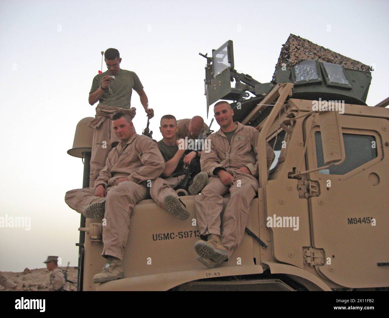 Sgt. Charlie Brown (seated far left), a Data Network Specialist with 2nd Marine Logistics Group (Forward), poses for a photo with the 3rd Machine Gun Squad, Weapons Platoon, Kilo Company, 3rd Battalion, 1st Marine Regiment, during their 2005 deployment to Iraq. Brown was awarded two Purple Heart Medals for wounds received in action on the same day during his deployment. ca. 2005 Stock Photo