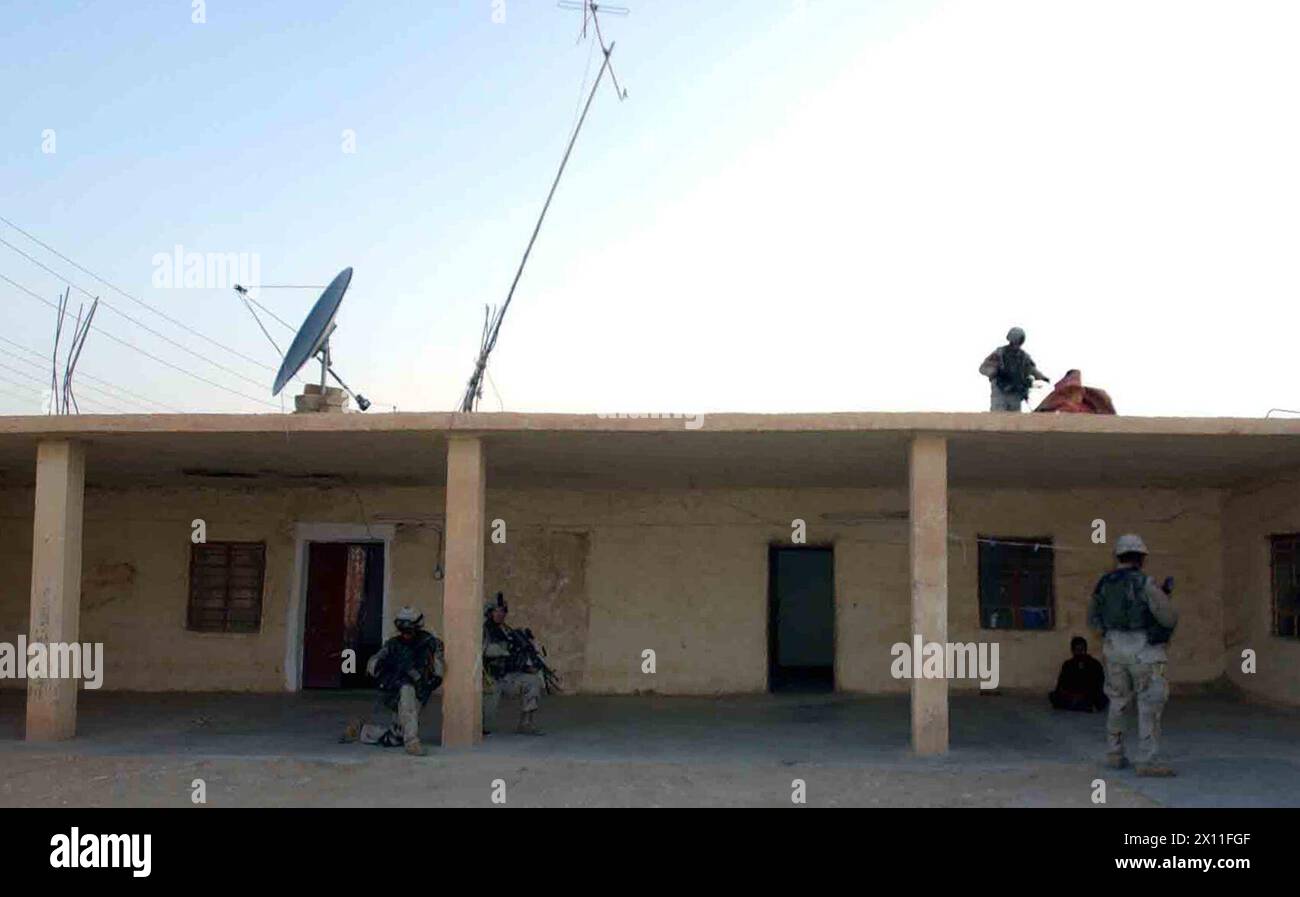 Soldiers from Company B, 5th Battalion, 20th Infantry Regiment, 3rd Brigade, 2nd Infantry Division (Stryker Brigade Combat Team) secure a home along the border between Iraq and Syria on Aug. 4, 2004. The residents are suspected of smuggling weapons into Iraq from Syria and distributing them to terrorist cells throughout Iraq. Stock Photo