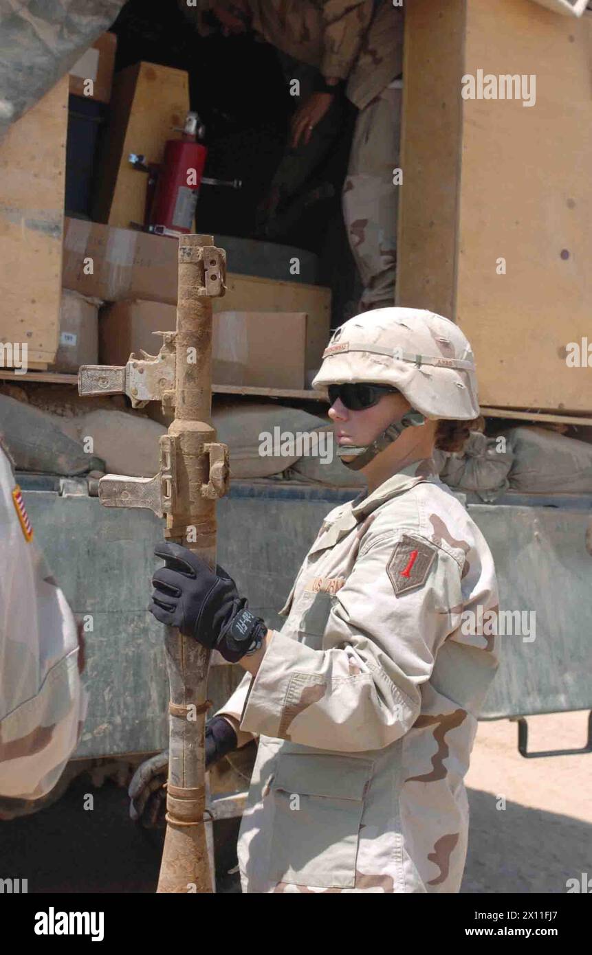 Spc. Amanda D. Goraczkowski, a tank turret mechanic with Bravo Company, 201st Forward Support Battalion, 1st Infantry Division, helps unload some Rocket Proprelled Grenade launchers which he delivered from Forward Operating Base Warhorse to Logistical Support Area Anaconda ca. 2004 Stock Photo