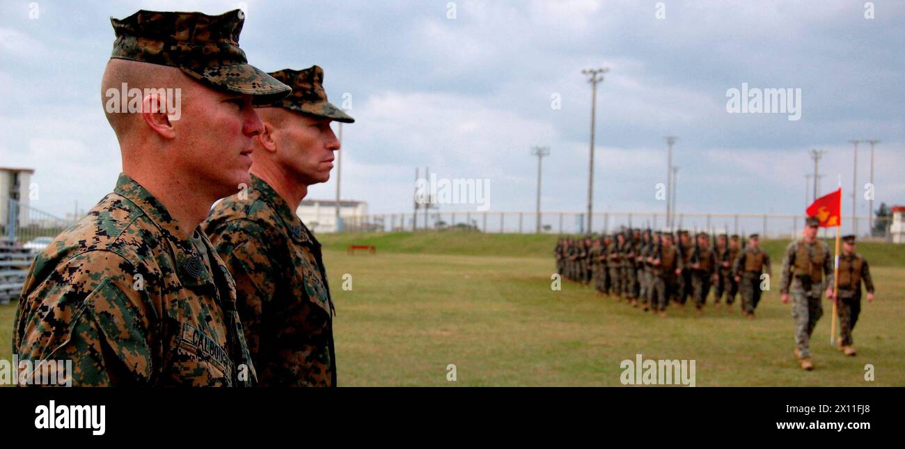 Sgt. Maj. James Calbough, front, incoming sergeant major for 9th Engineer Support Battalion, 3rd Marine Logistics Group, III Marine Expeditionary Force, and Sgt. Maj. John Ploskonka, the battalion's outgoing sergeant major, inspect their troops as they conduct a pass in review at Camp Hansen's parade deck during a Jan. 7, 2010 practice for a ceremony. Stock Photo