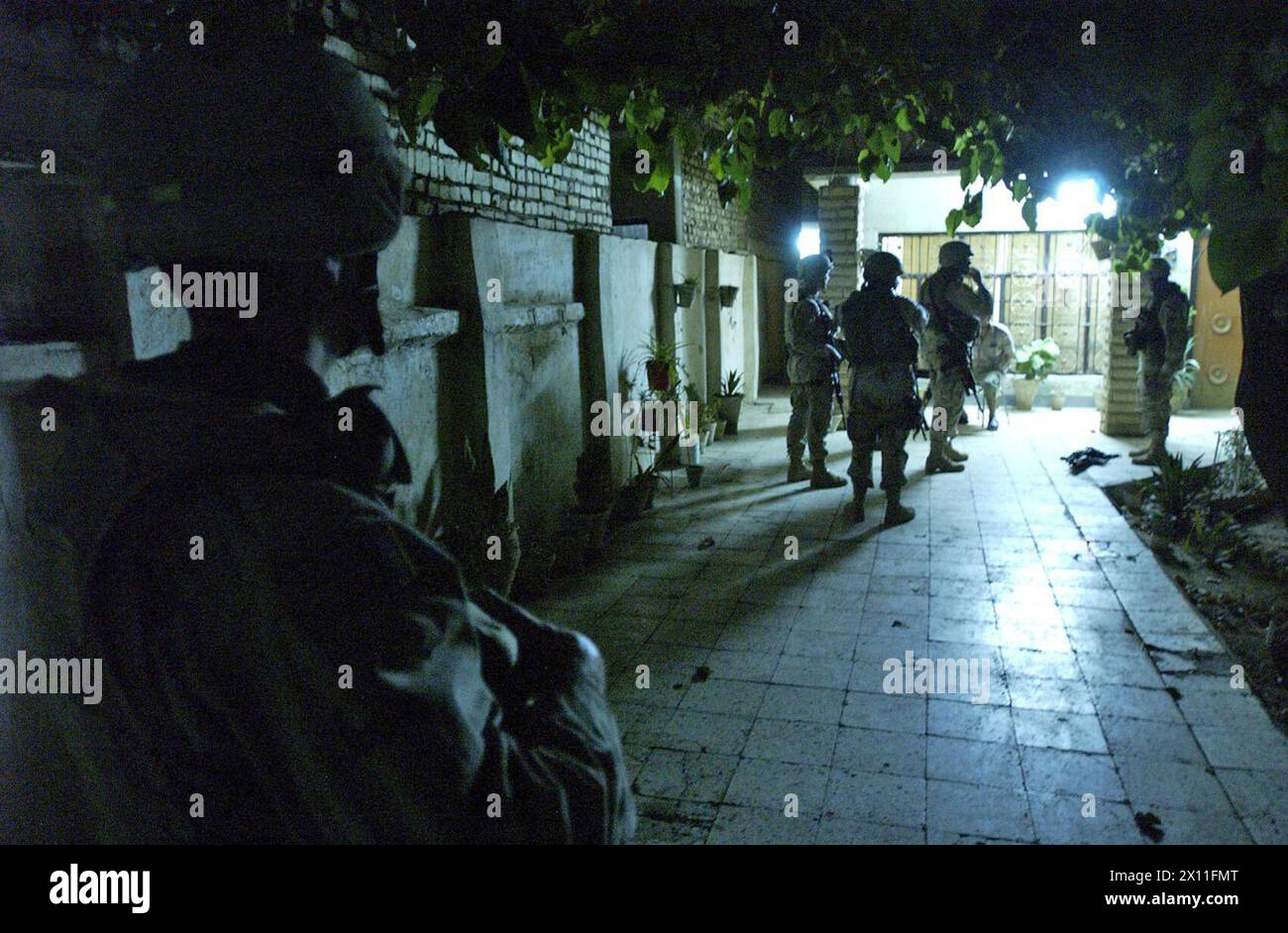 Soldiers maintain security during the search of an Al Doura Iraq home which yielded a suspected terrorist during the 1st Battalion 8th Cavalry Regiment operation July 30 2004. Stock Photo