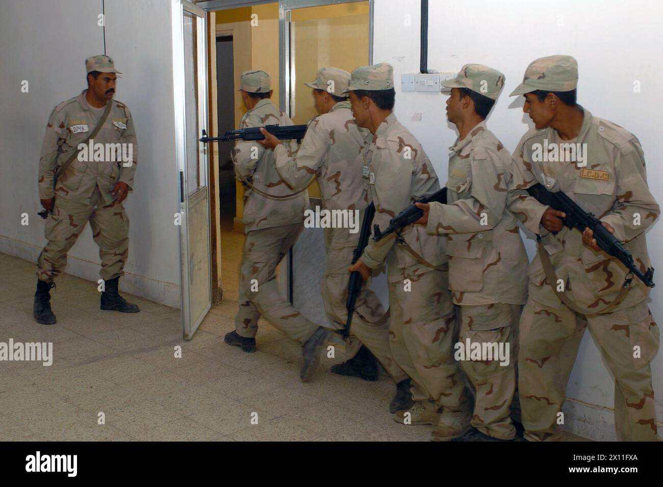 Iraqi National Guard soldiers practice entering a room during a four-week basic training course taught by Soldiers from Company C, 52nd Infantry Regiment, 3rd Brigade, 2nd Infantry Division (Stryker Brigade Combat Team) in Qayarrah, Iraq ca. July 14, 2004 Stock Photo