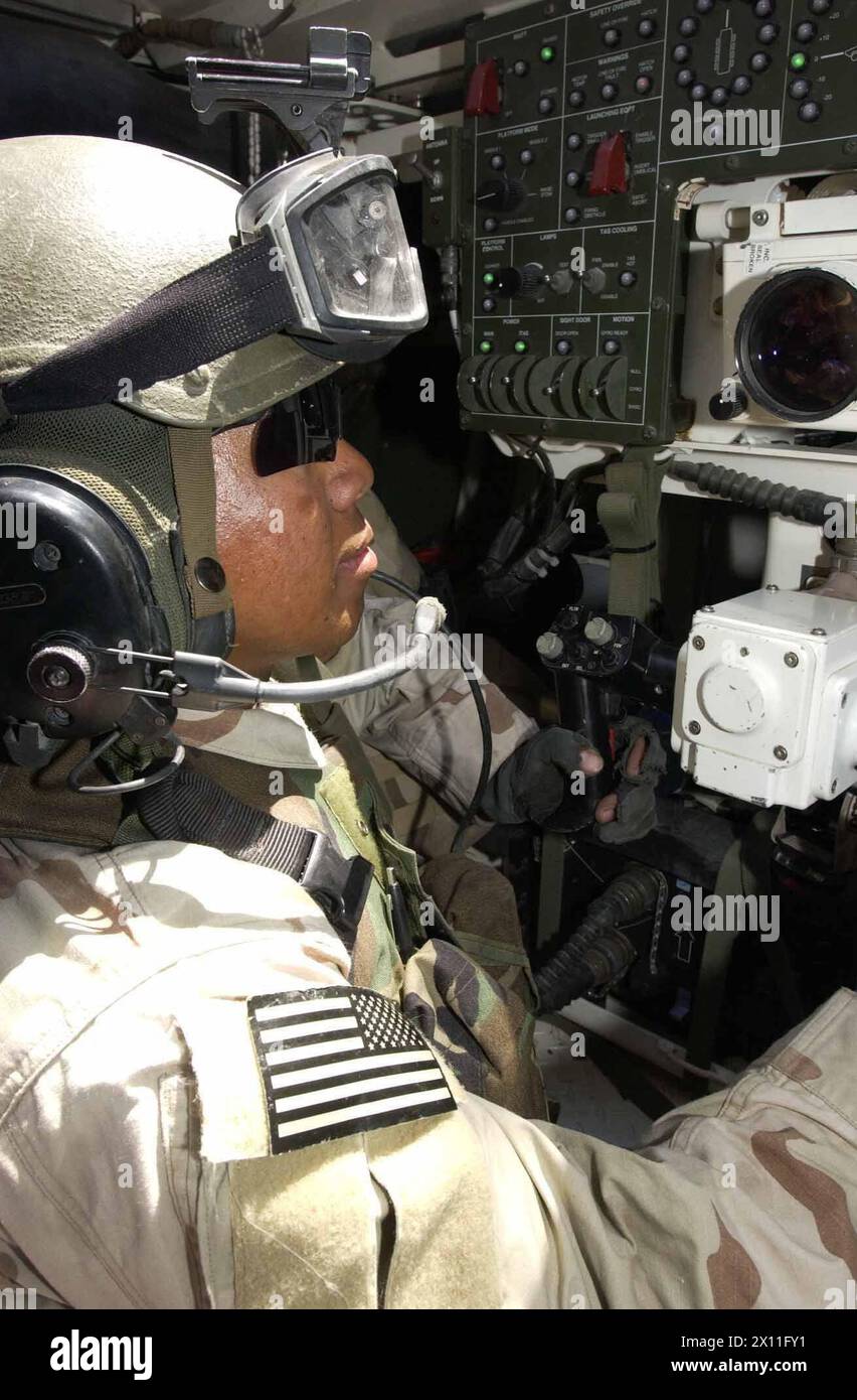 Spc. Michael Ortega with Company A, 2nd Battalion, 3rd Infantry Regiment, 3rd Brigade, 2nd Infantry Division (Stryker Brigade Combat Team) operates a weapon system from the gunners seat inside a Stryker vehicle. Ortegas platoon patrols the streets of Mosul in conjunction with Iraqi National Guard soldiers to maintain peace and security in the city ca. July 16, 2004 Stock Photo