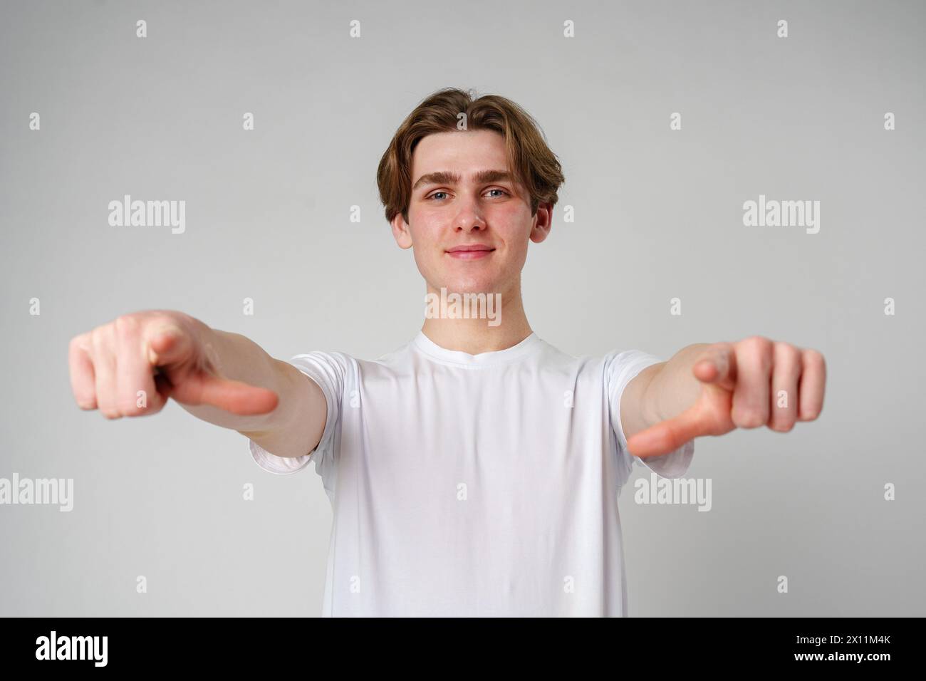 Young Man in White T-Shirt Pointing at Camera Stock Photo