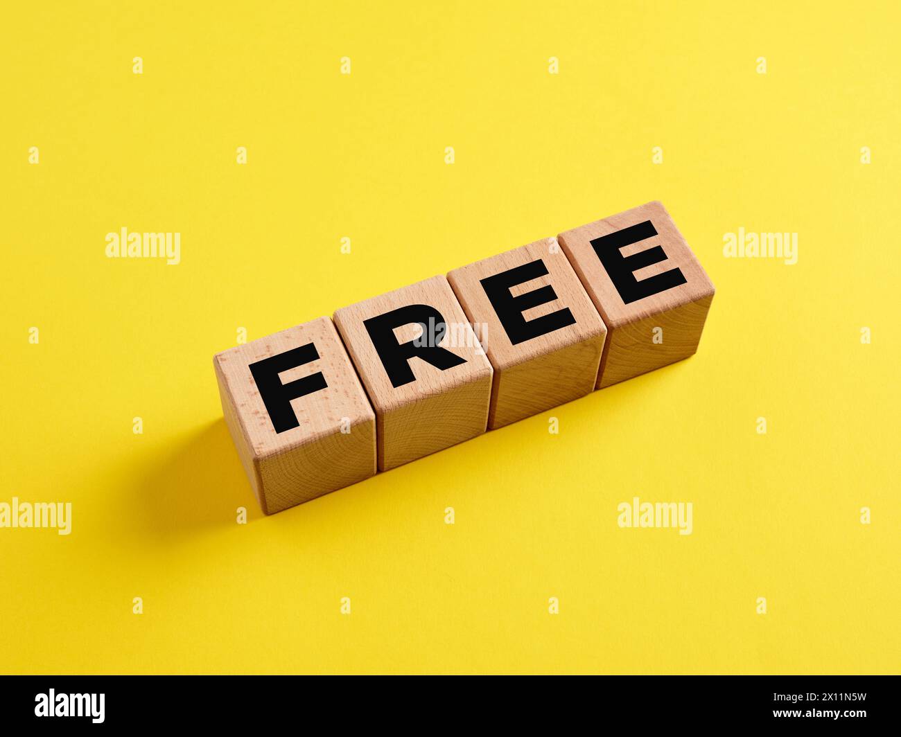 The word Free on wooden cubes on yellow background. Free of charge ...