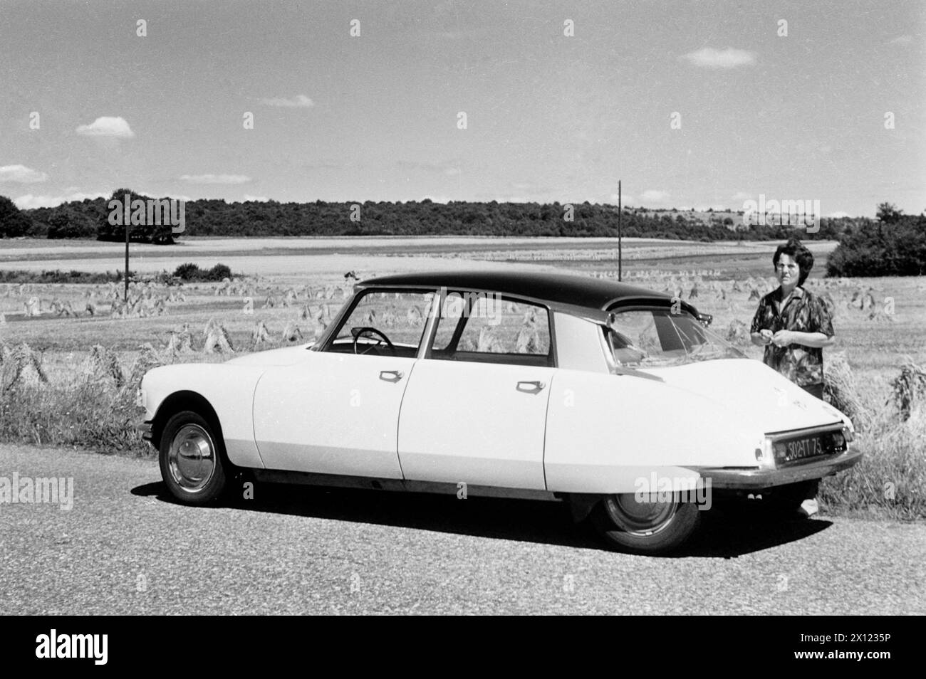 Citroën DS, manufactured 1955-1975, in Countryside Setting with Hay Hales & Woman, probably in Germany, Europe. Vintage or Historic Monochrome or Black and White Image c1960. Stock Photo