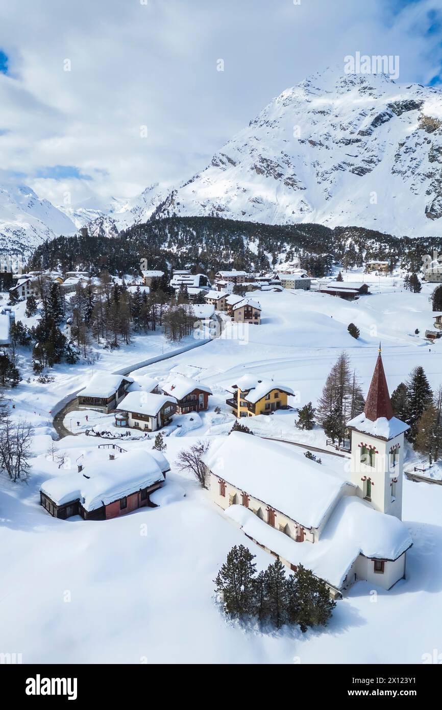 Aerial view of the Chiesa Bianca covered in snow. Maloja, Bregaglia, canton of Graubunden, Engadin, Switzerland. Stock Photo