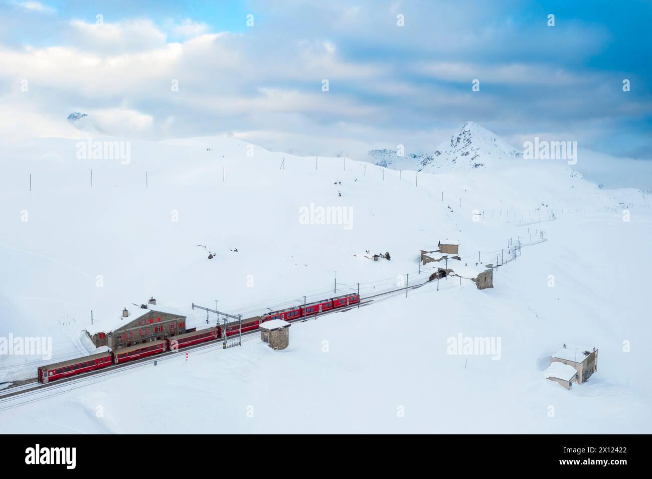 Aerial view of the famous Bernina Express passing through at Bernina pass in winter. Graubunden, Engadin, Switzerland. Stock Photo