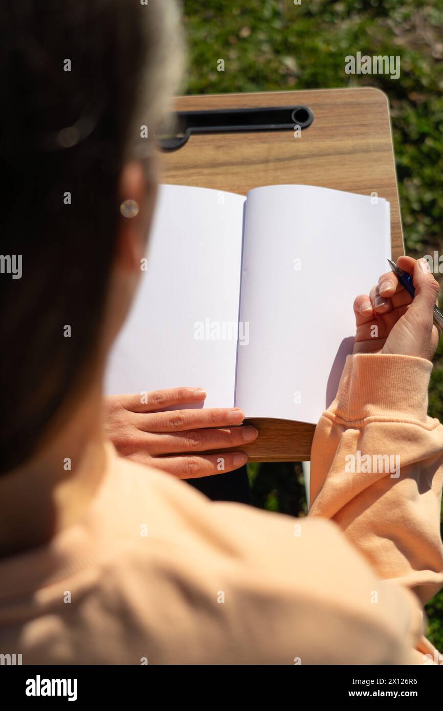 Woman writing in a blank notebook. Copy space Stock Photo