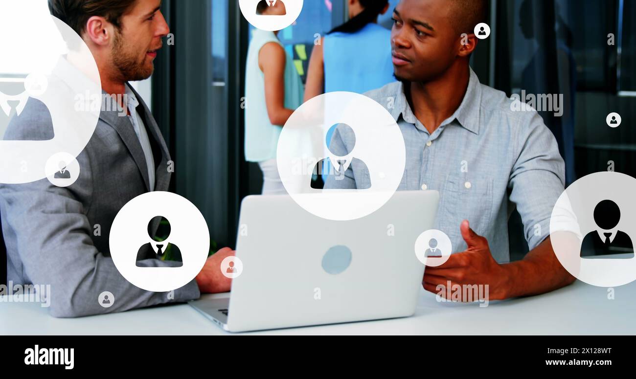 Image of multiple profile icons over diverse entrepreneurs sharing ideas in office Stock Photo