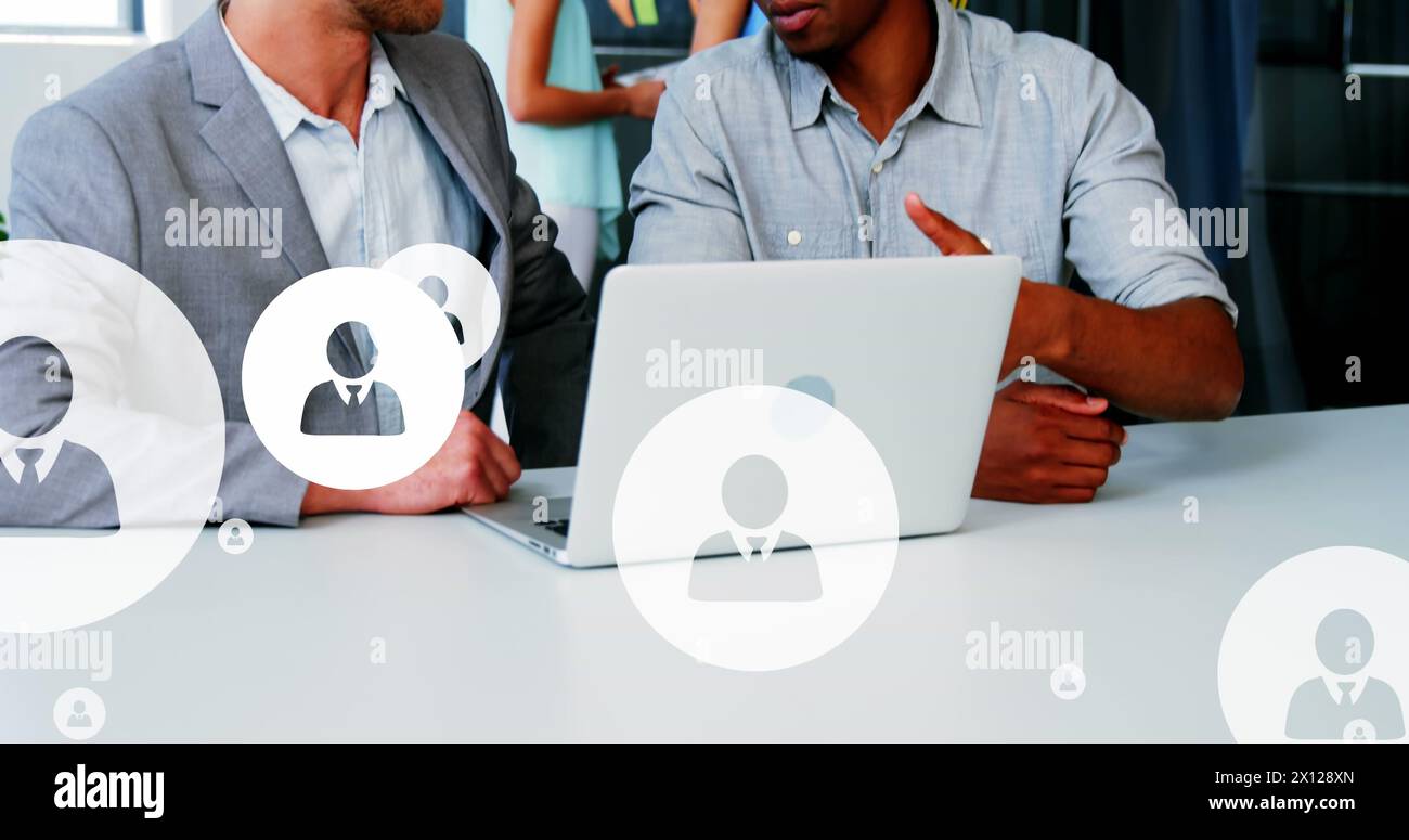 Image of multiple profile icons over diverse entrepreneurs discussing in office Stock Photo