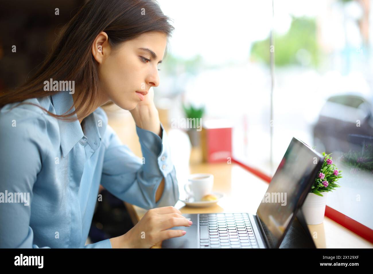 Elegant woman in a coffee shop working using tablet or laptop Stock ...