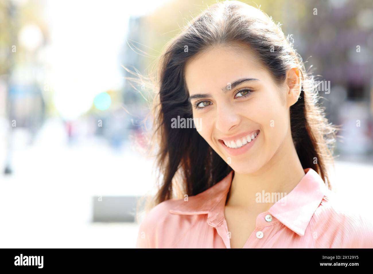 Portrait of a happy woman with white smile posing standing in the street Stock Photo