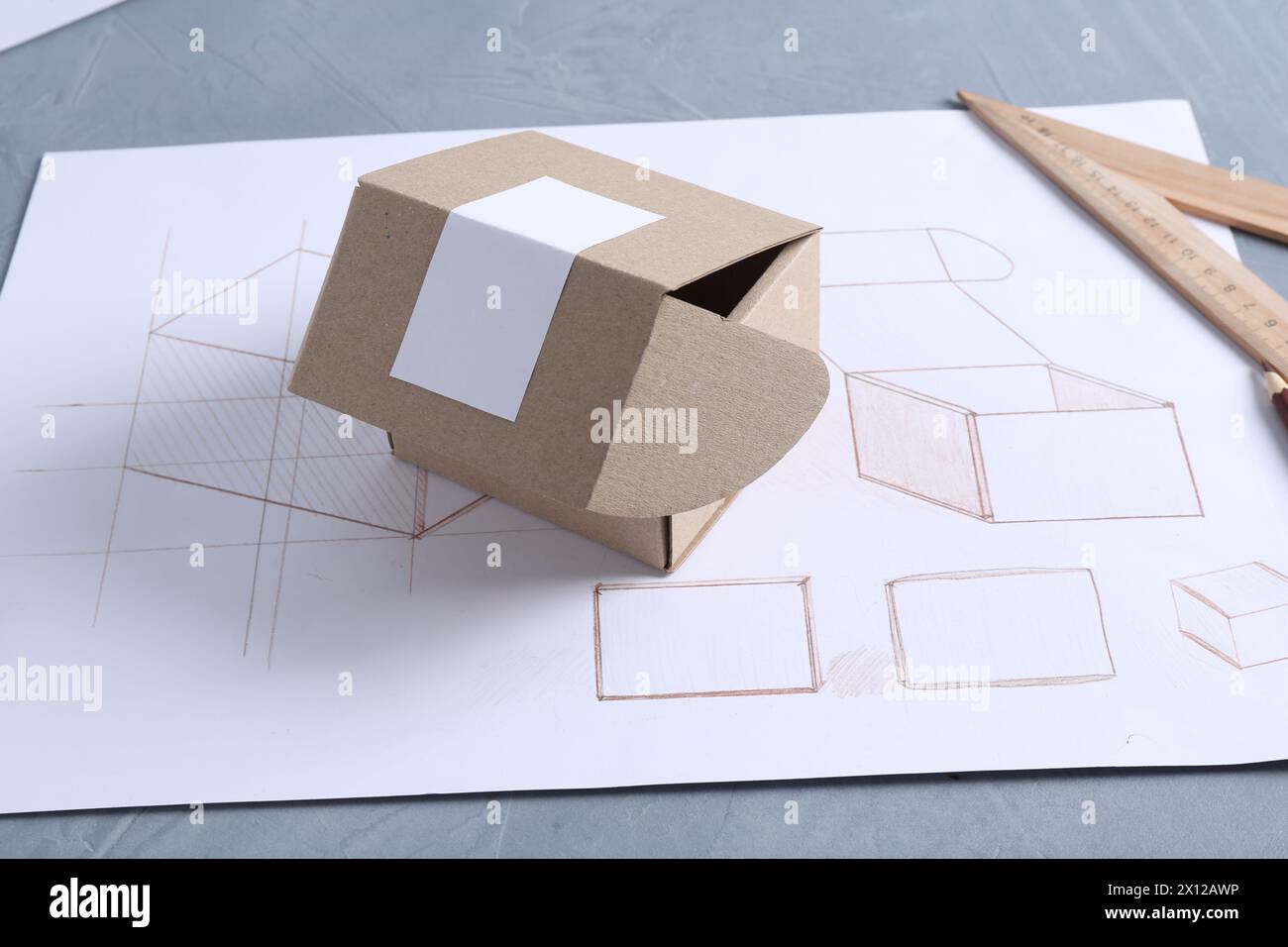 Creating packaging design. Drawing, box and ruler on blue textured ...