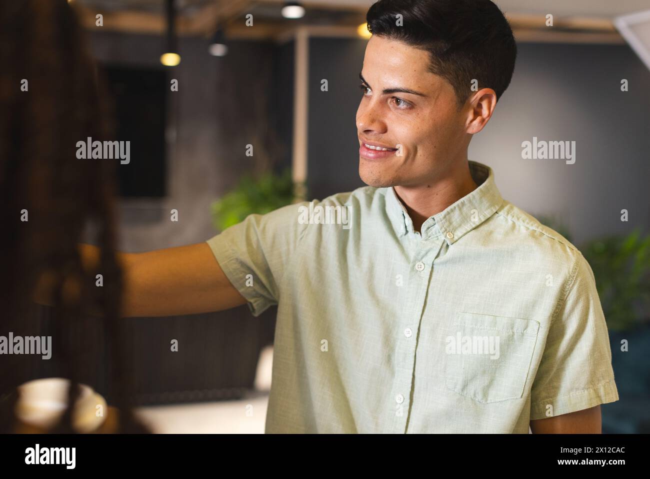 A young biracial man examining clothes in a modern business office store Stock Photo