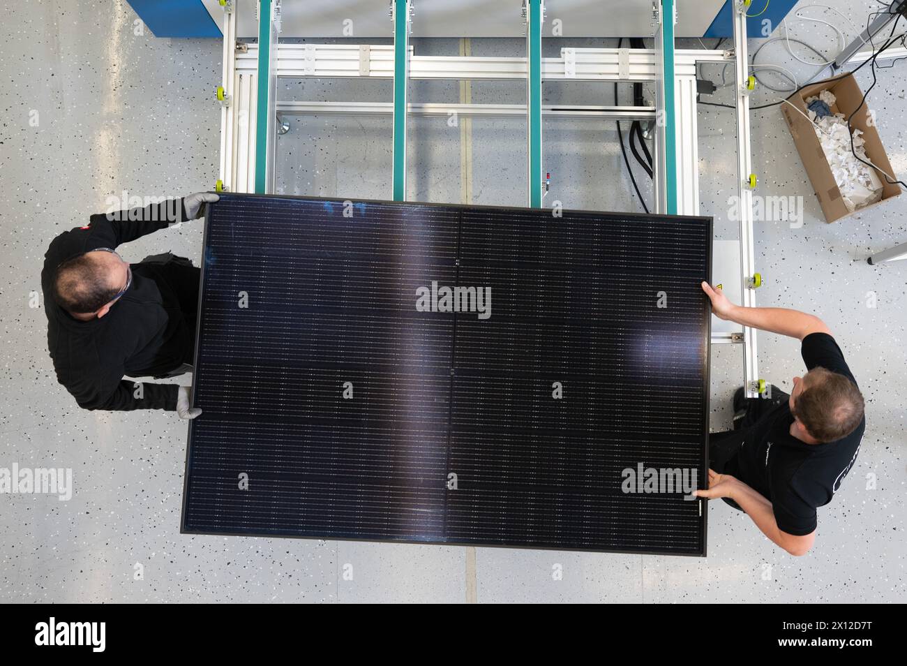 Ottendorf Okrilla, Germany. 15th Apr, 2024. Employees of the solar start-up Sunmaxx work on a PVT module in module production. This is a combination of photovoltaic and solar thermal modules. Credit: Sebastian Kahnert/dpa/Alamy Live News Stock Photo