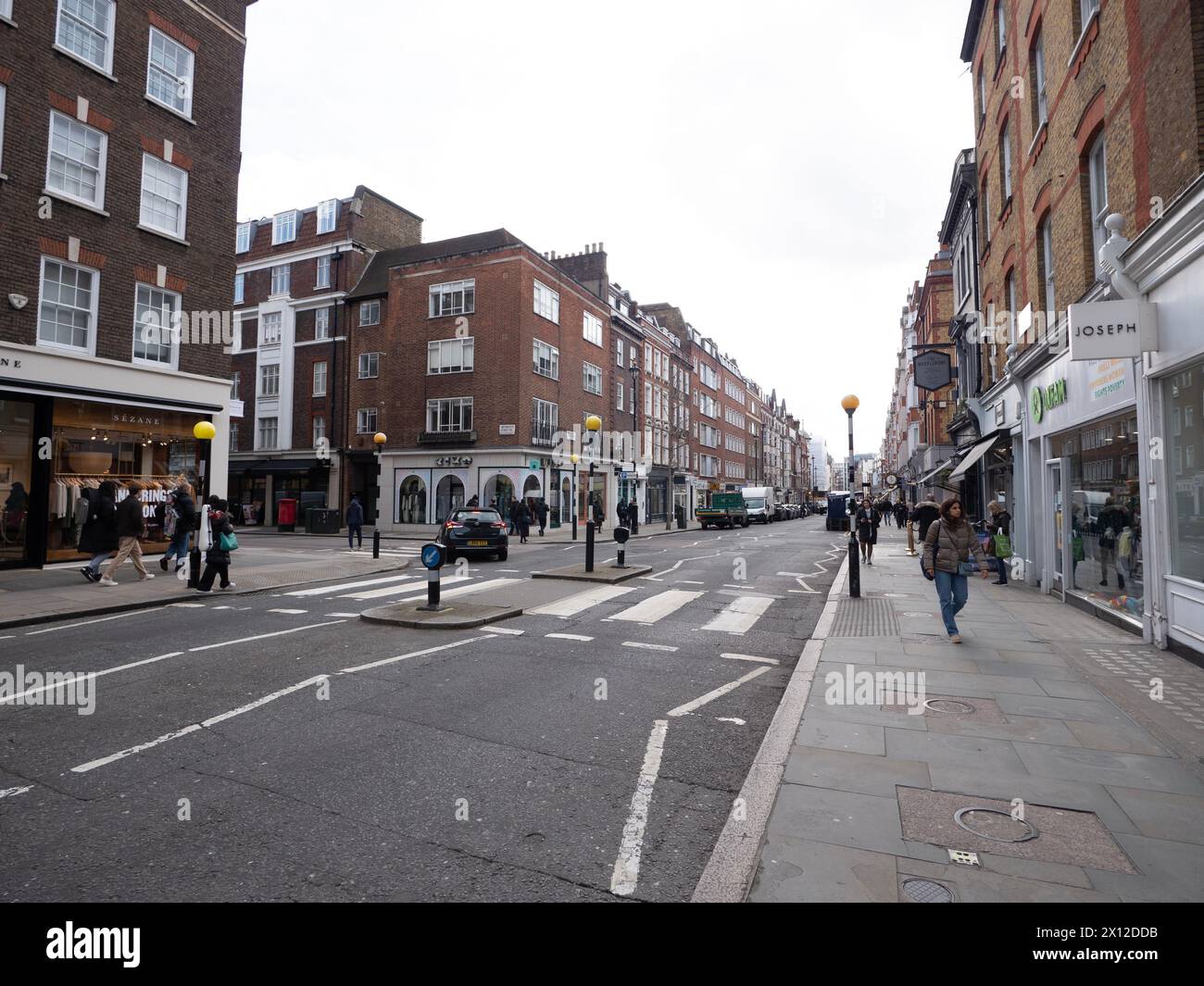 Marylebone high street London with retail shops and  stores with  pedestrian crossing in foreground Stock Photo