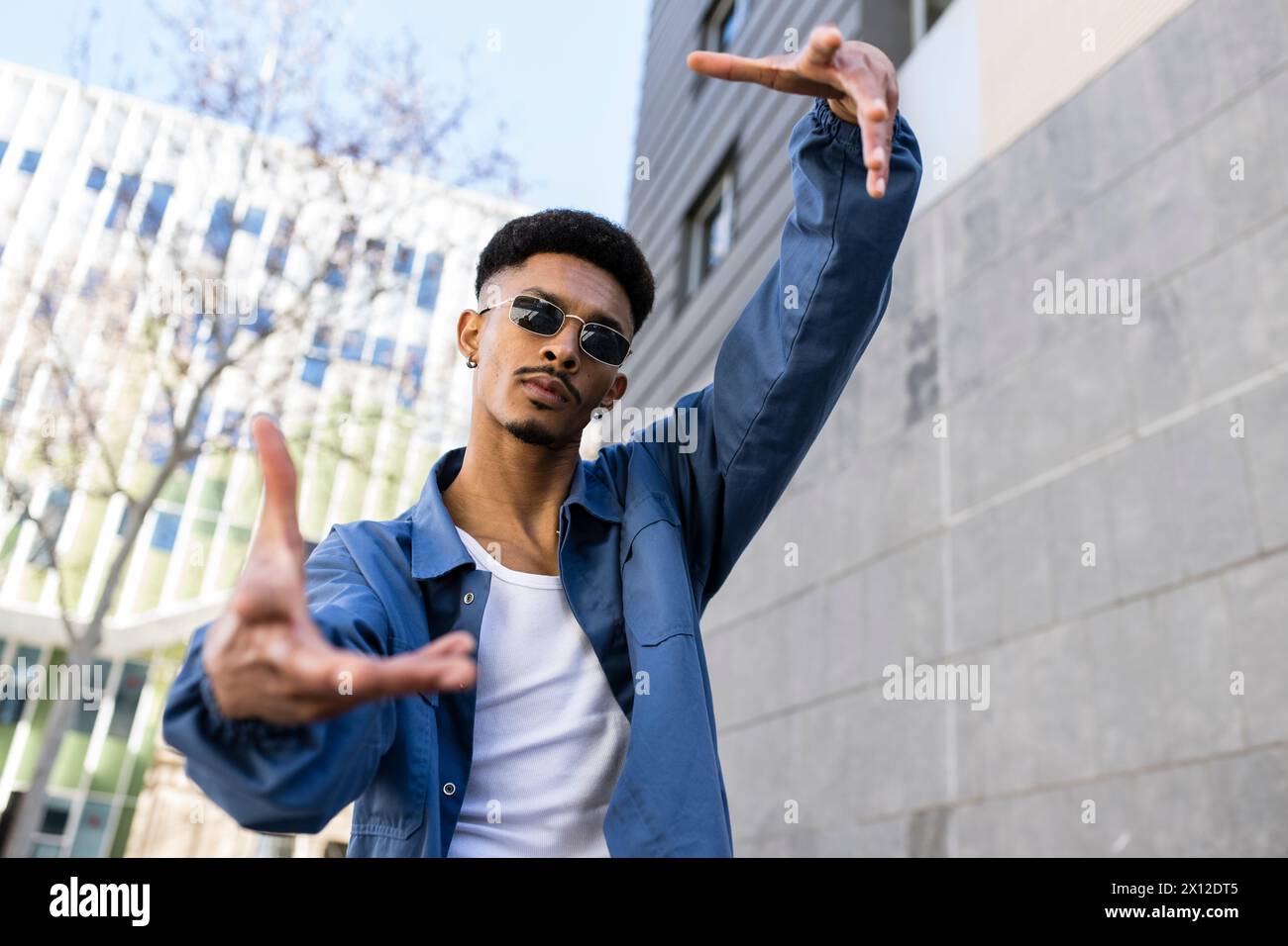 Young confident male performing gesture outside looking at camera. Stock Photo