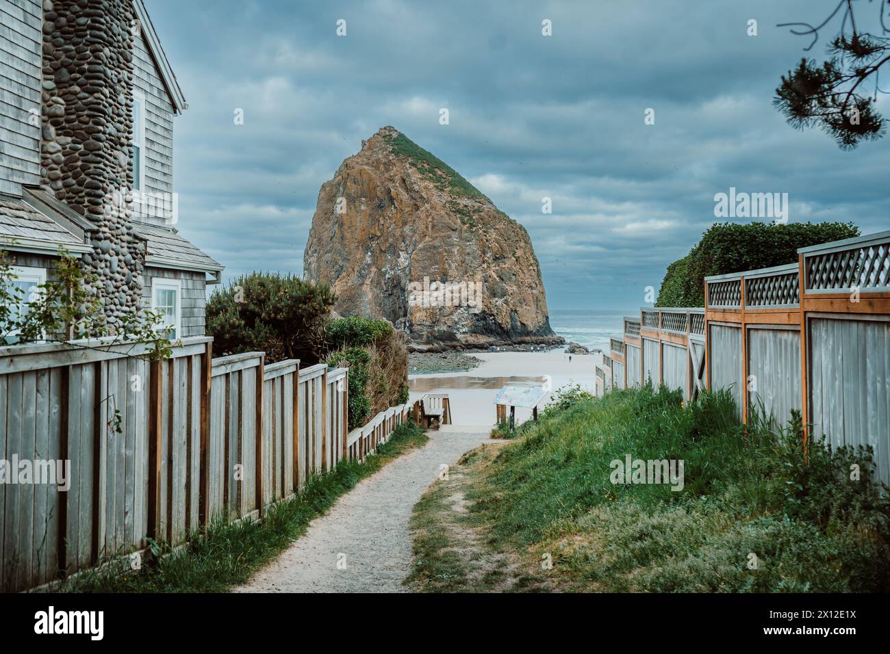 Path leading between fences to Cannon Beach on a stormy day Stock Photo