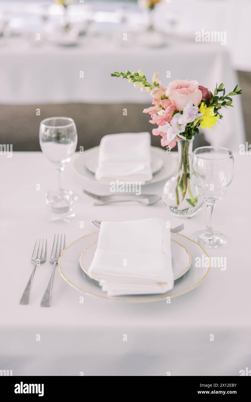 Elegant wedding table setting with pink floral accent Stock Photo