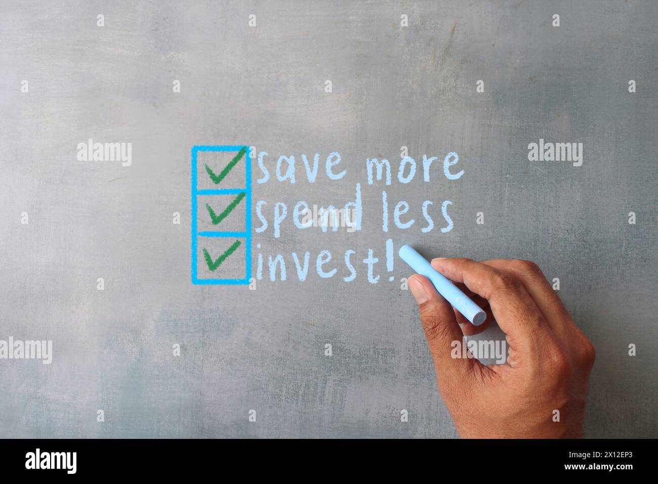 Hand writing on chalkboard text SAVE MORE, SPEND LESS, INVEST. Financial concept. Stock Photo