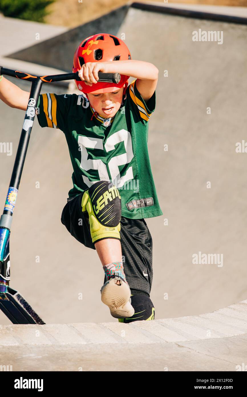 Young boy walking up skate ramp with skateboard Stock Photo - Alamy