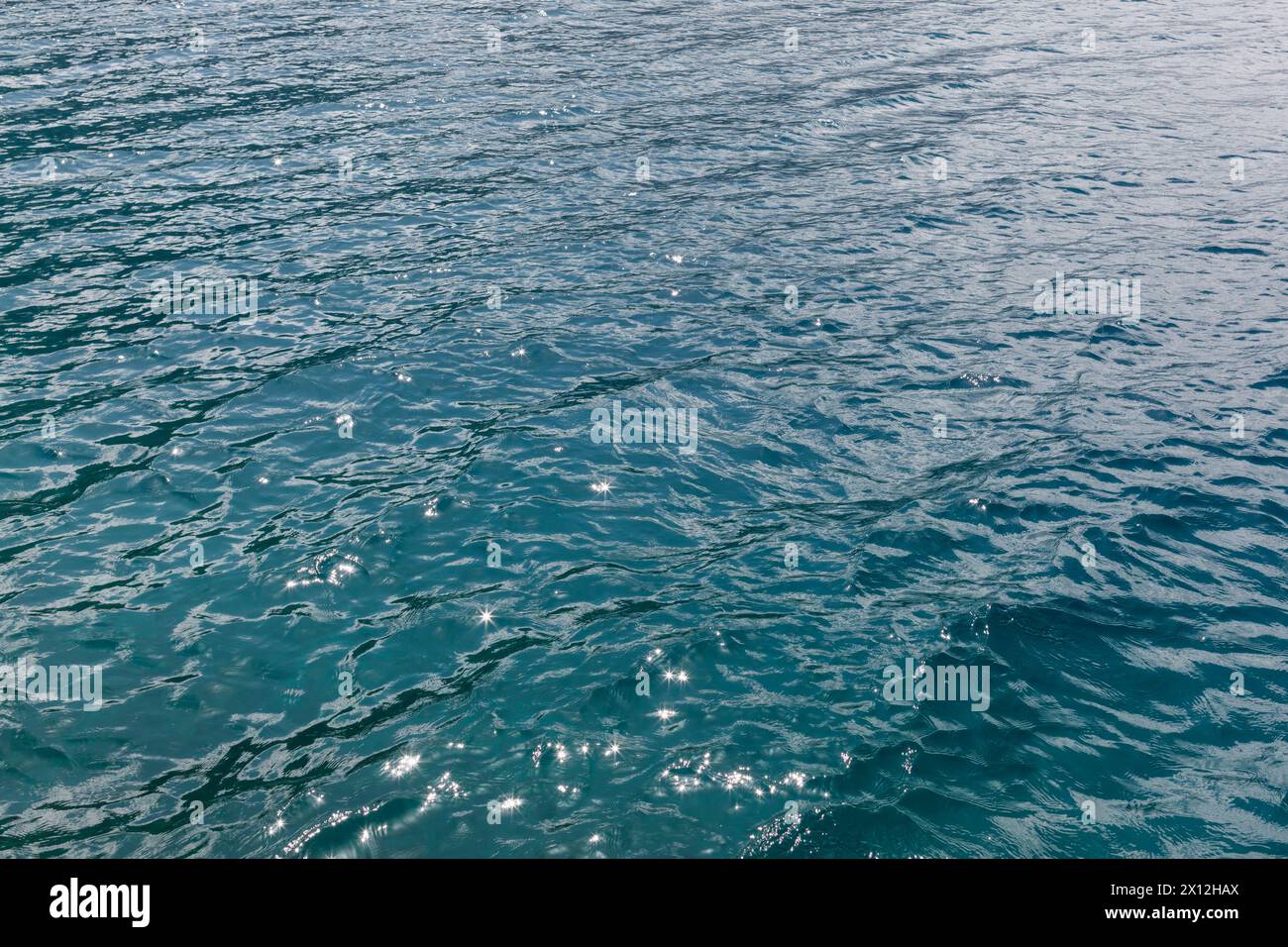 Calm waves with sparkles on blue water Stock Photo