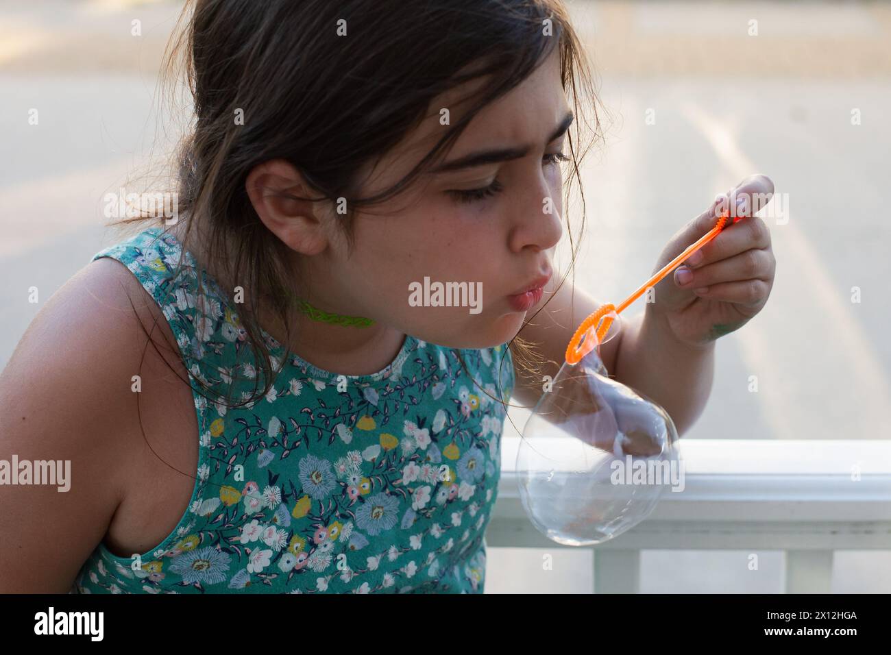 Girl with brown hair blowing bubbles Stock Photo