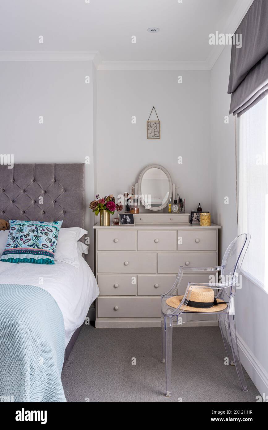 Bedside storage with designer chair in London flat, UK Stock Photo