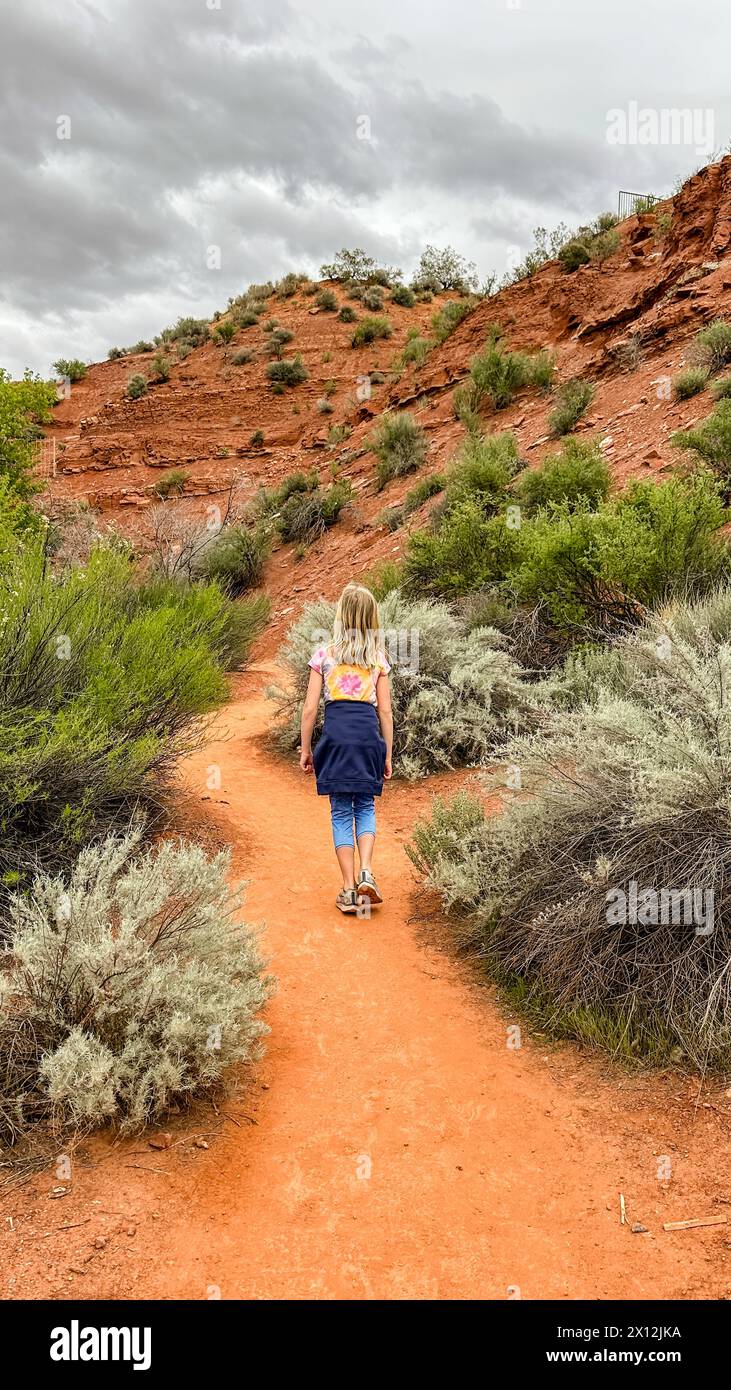 Young girl aged 6-9 hiking on a peaceful desert trail Stock Photo