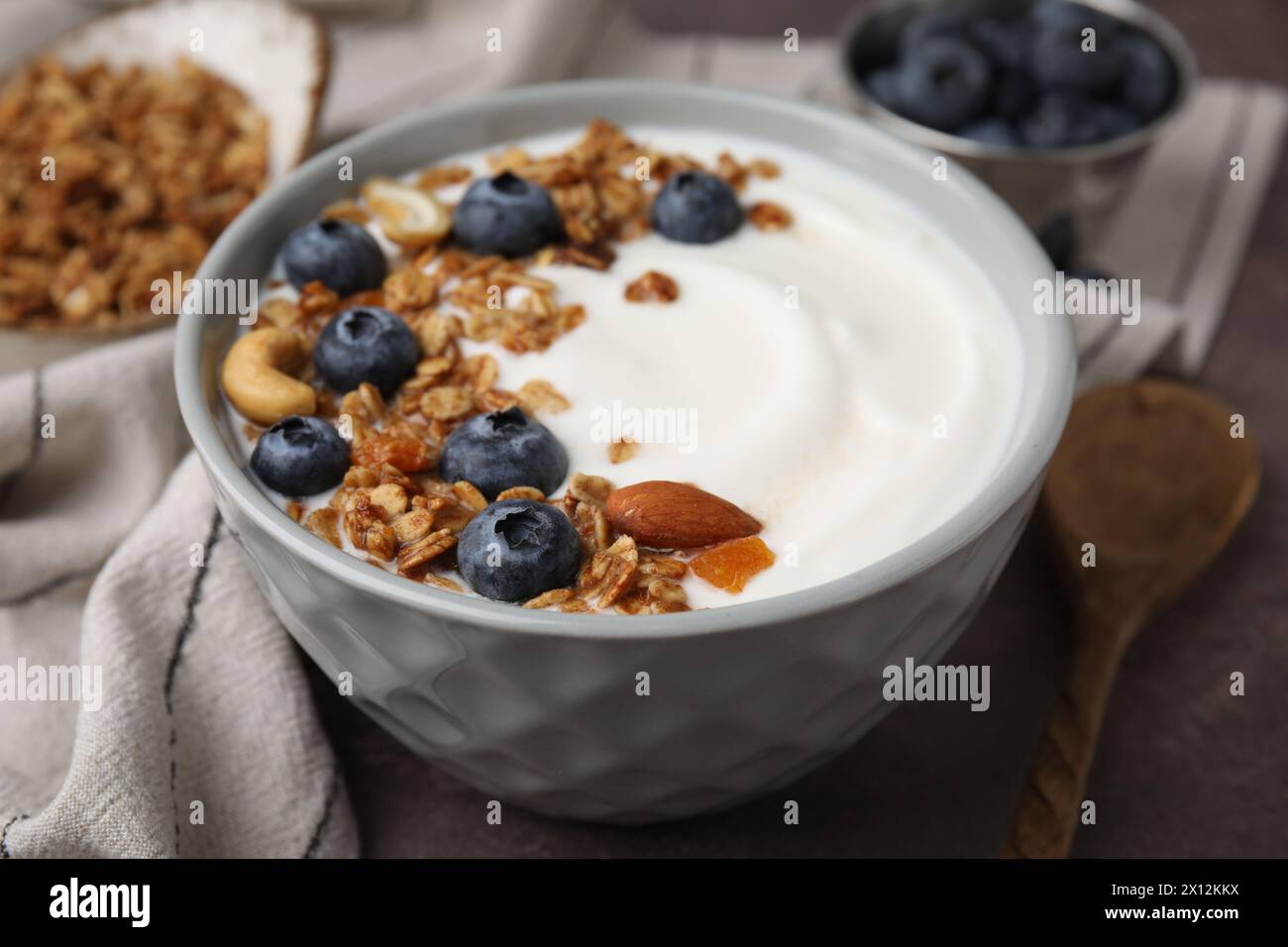 Bowl with yogurt, blueberries and granola on grey table, closeup Stock Photo