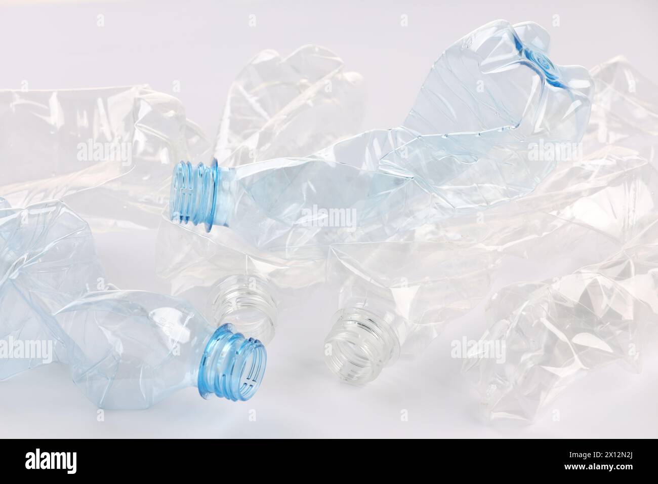Crumpled disposable plastic bottles on white background Stock Photo - Alamy