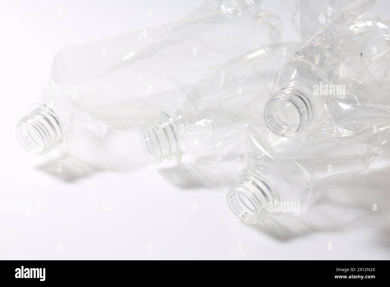 Crumpled disposable plastic bottles on white background Stock Photo - Alamy
