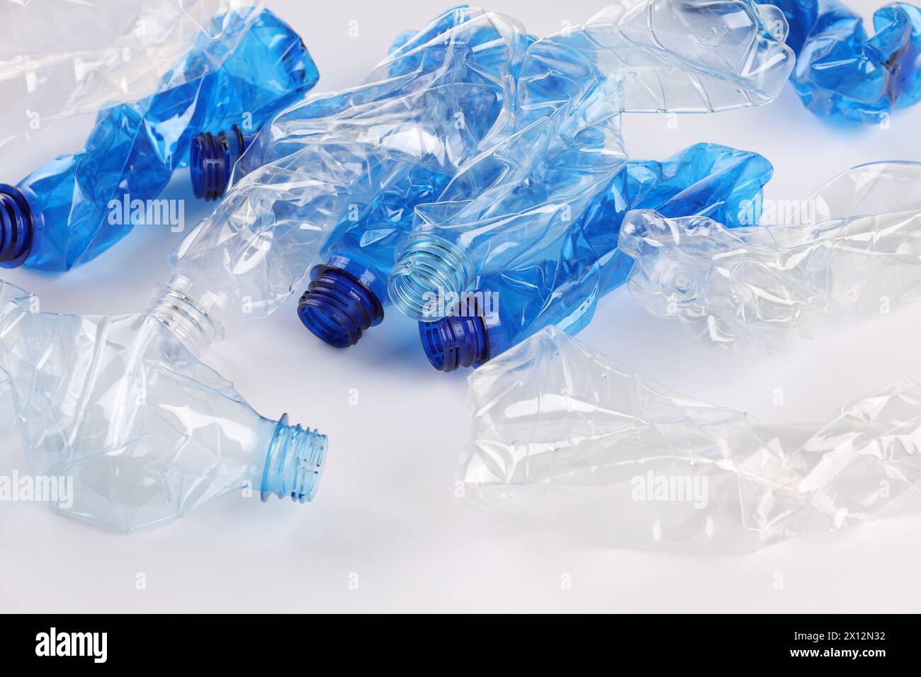 Crumpled disposable plastic bottles on white background Stock Photo - Alamy