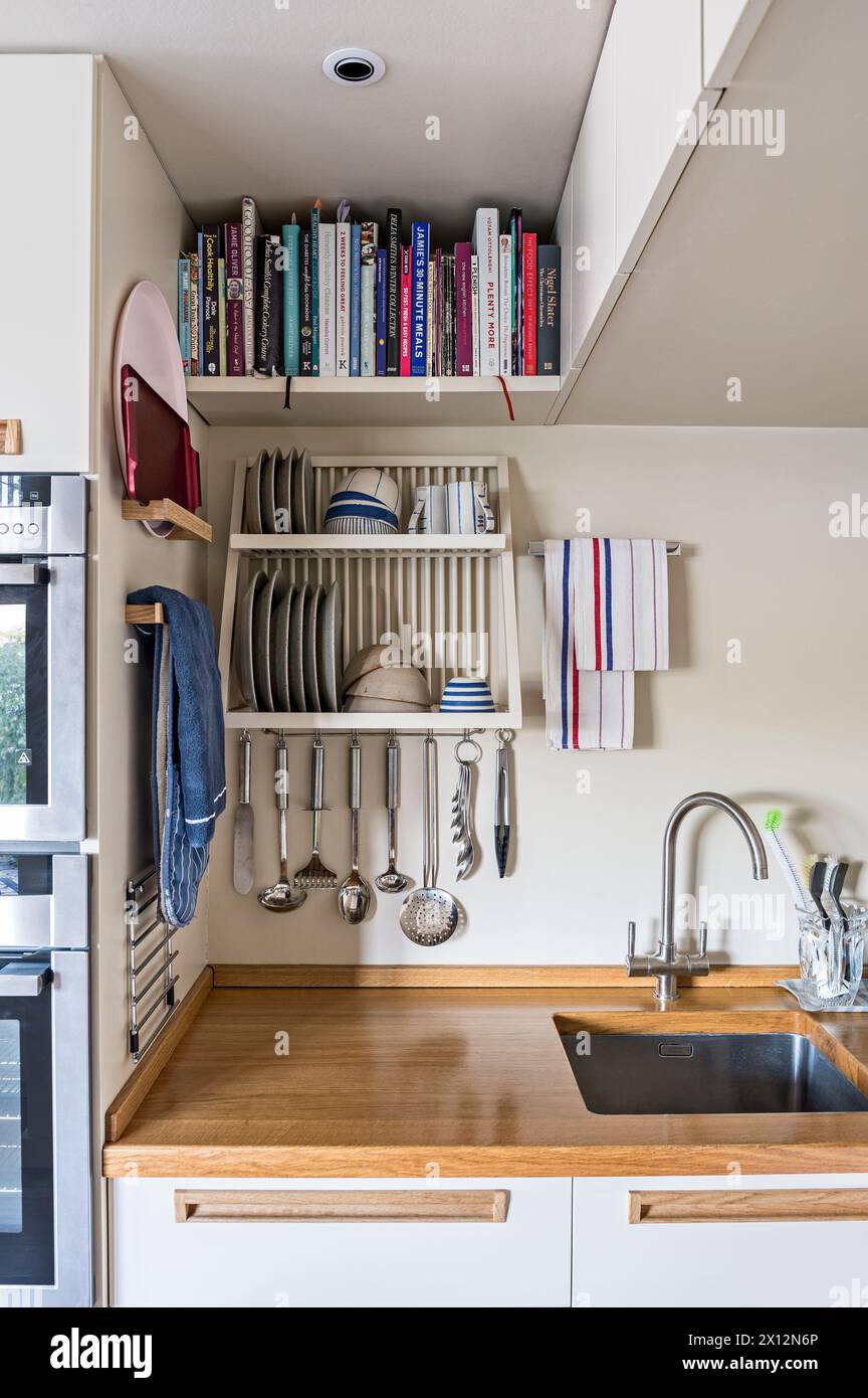 Recipe books and plate rack in tidy kitchen of Thames waterside residence, London, UK Stock Photo