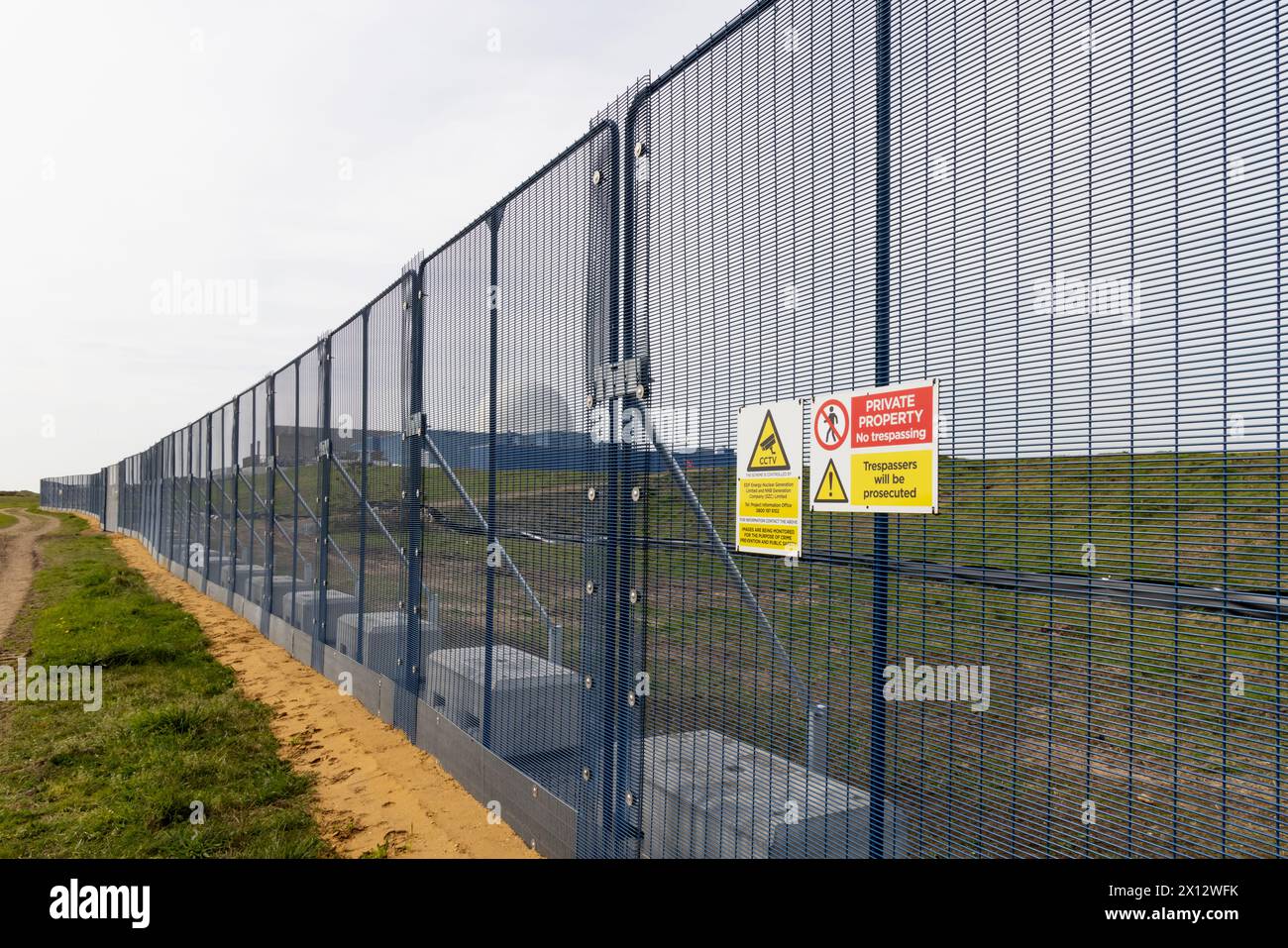 New fencing erected at the forthcoming Sizewell C nuclear power station construction site, with the Sizewell B reactor dome in the background. Stock Photo