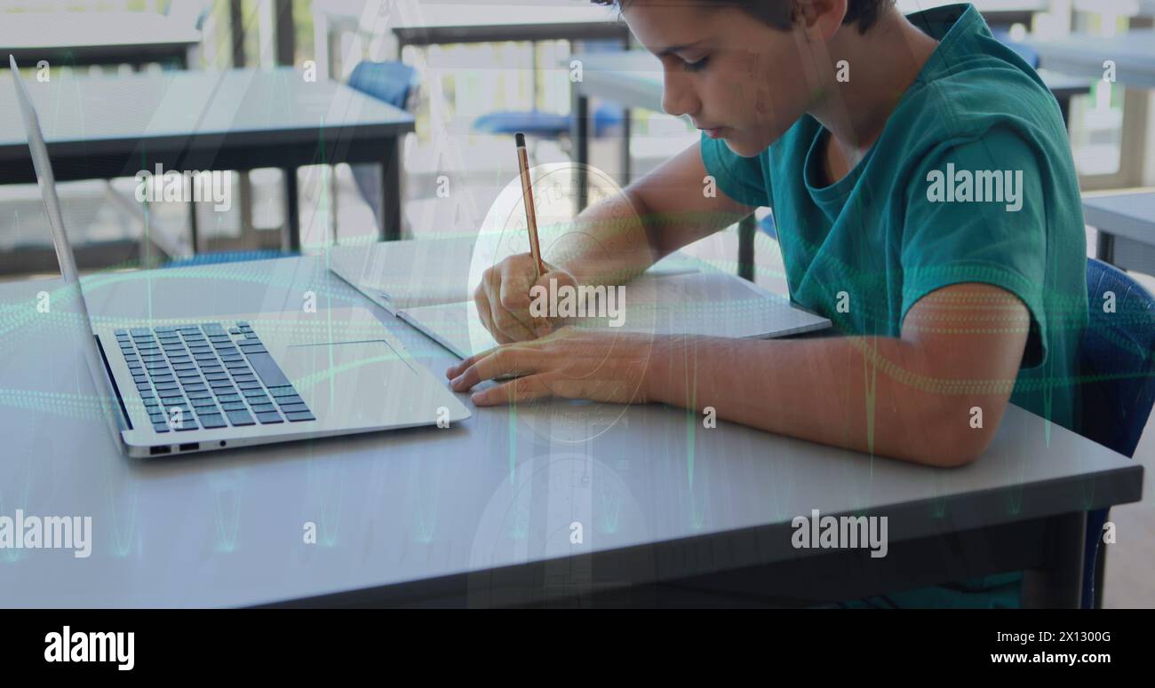 Image of data processing over caucasian student writing on notebook with laptop in classroom Stock Photo