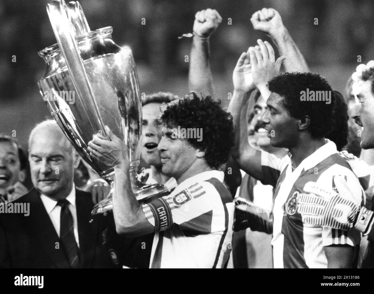The soccer club FC Porto wins 2:1 against the soccer team of Bavaria-Munich on 27th of May 1987 at the European Cup. Picture: Celso (r.), Joao Pinto (middle) got the cup from the UEFA president Jacques Georges (L). - 19870527 PD0008 - Rechteinfo: Rights Managed (RM) Stock Photo